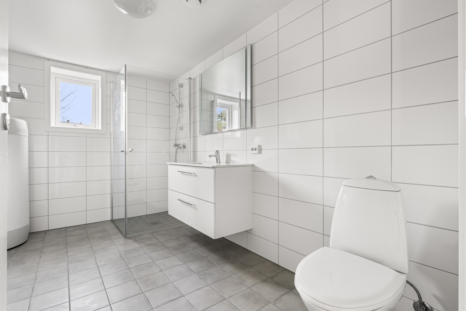 Badet er flislagt på gulv og vegger, med varmekabler i gulv Galleribilde
