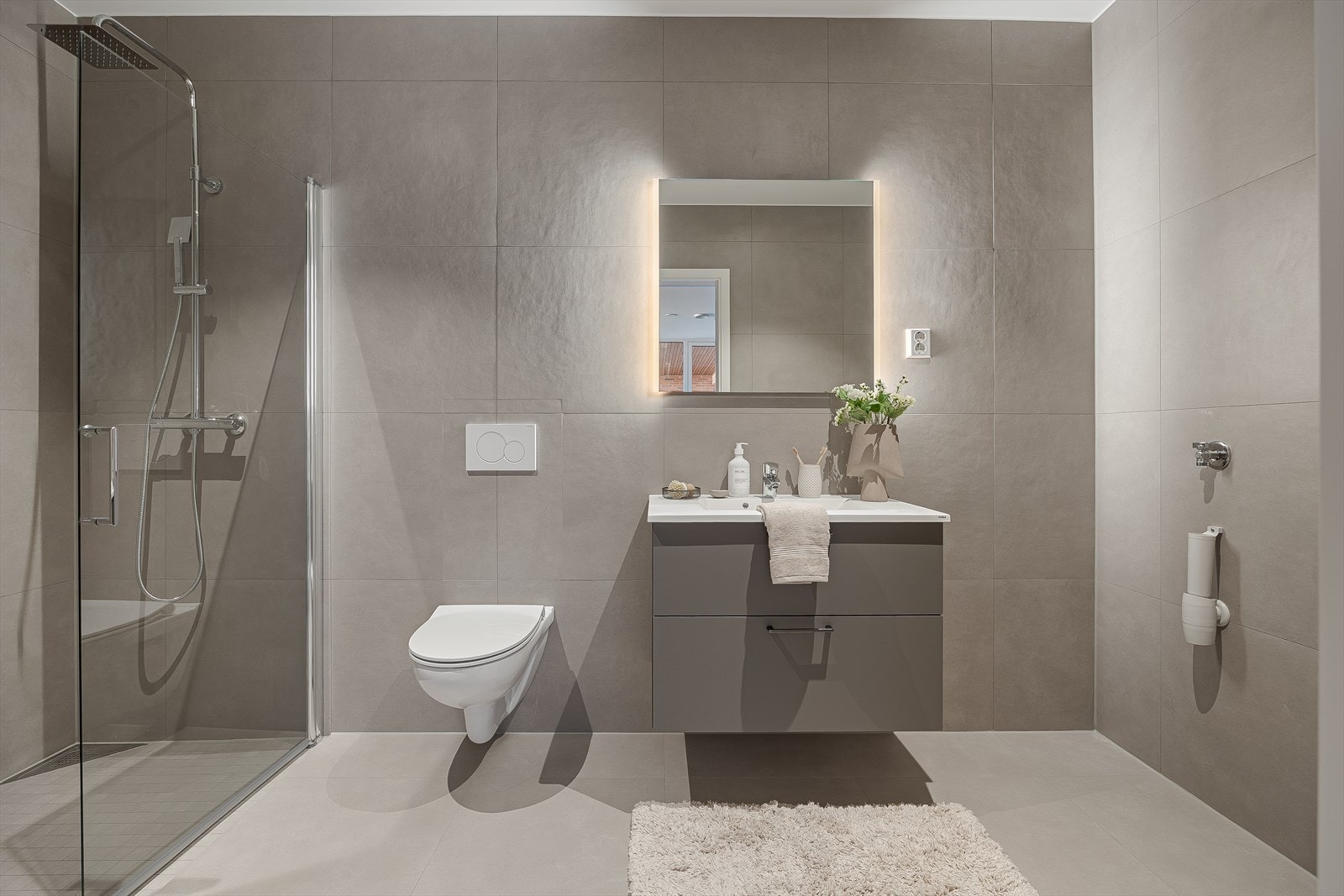 Helfliset baderom med vegghengt toalett - dusj og tilkobling for vaskemaskin og tørketrommel. Galleribilde