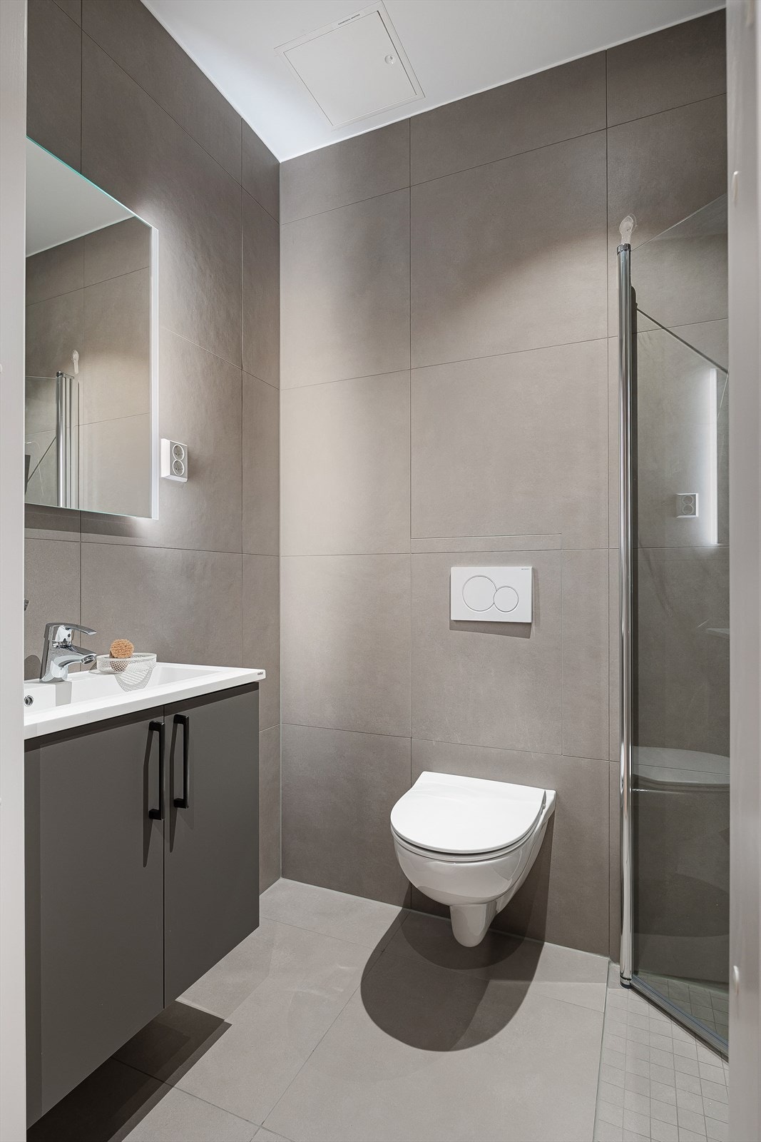 Helfliset baderom med vegghengt toalett og dusj. Galleribilde