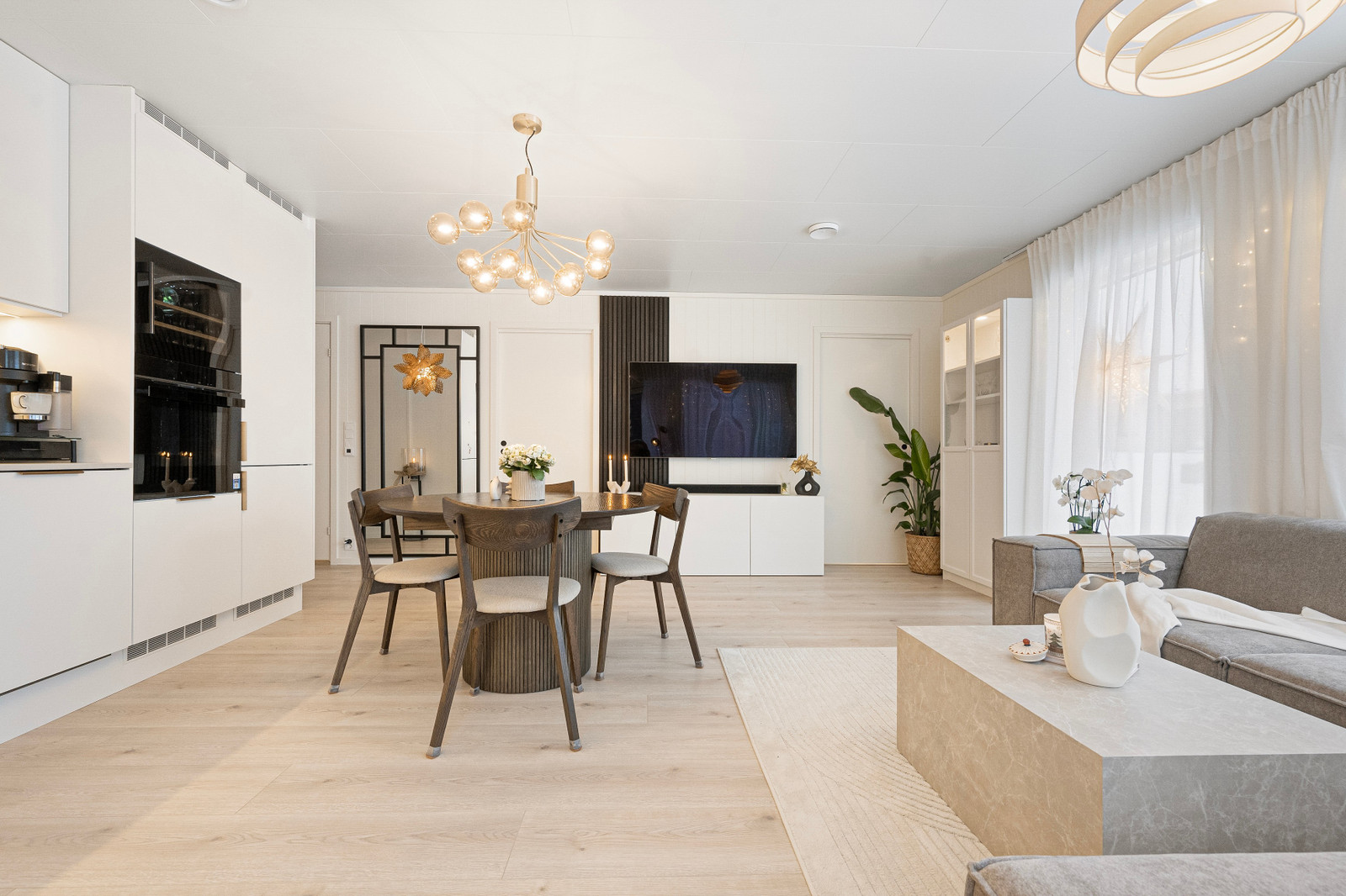 God plass til spisestue. Inngang til soverom på hver sin side av TV-veggen.