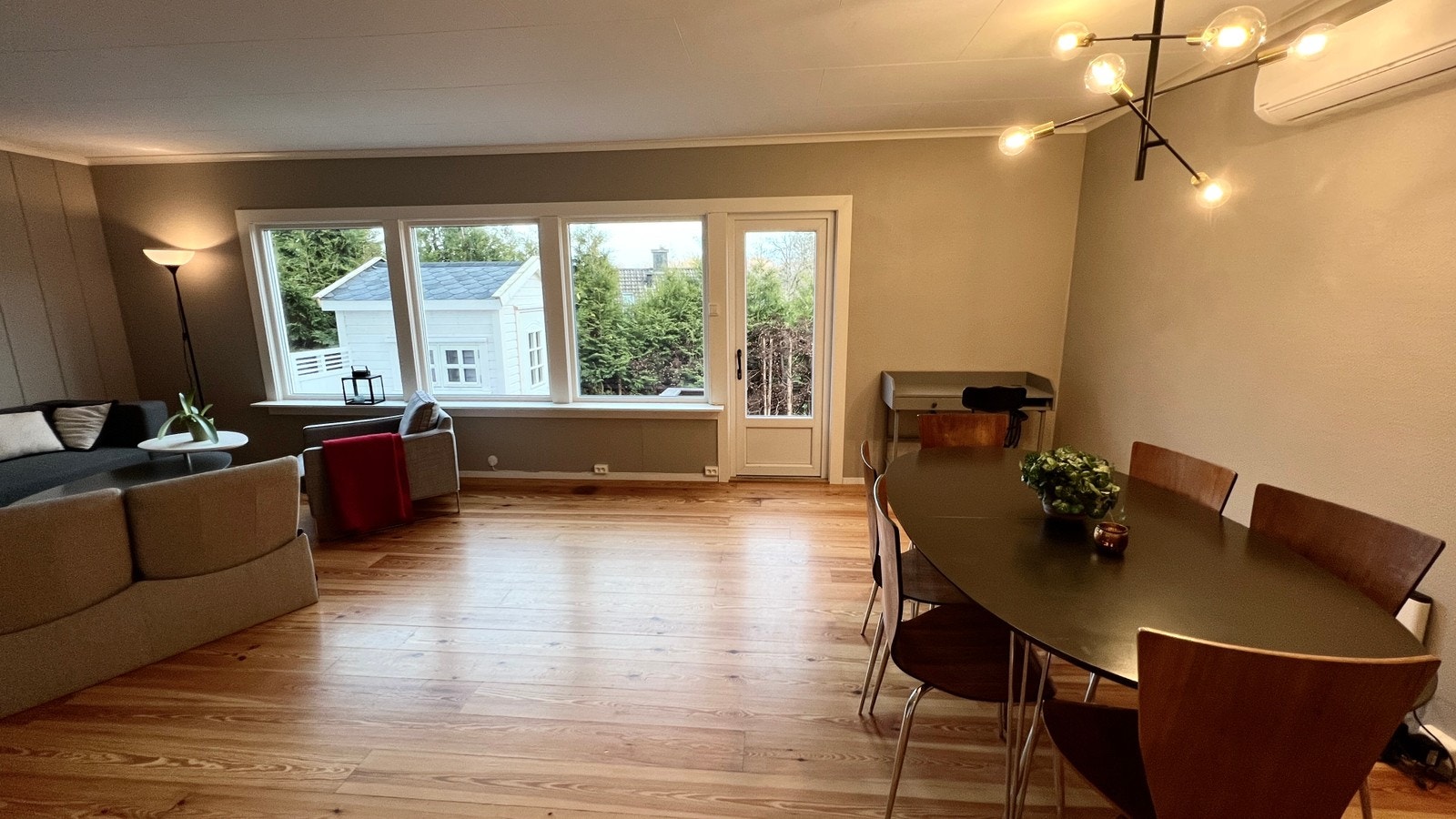 Stue med varmepumpe/air condition, ny himling og utgang til hage, bod og terrasseplatting. God plass til både spisestue og sofagruppe med TV. Galleribilde