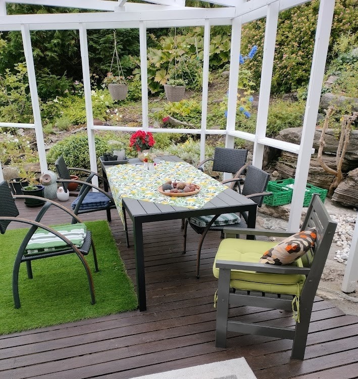 Bakken bak huset med stauder, frodig vegetasjon og vakre berg omringer spiseplassen. Galleribilde