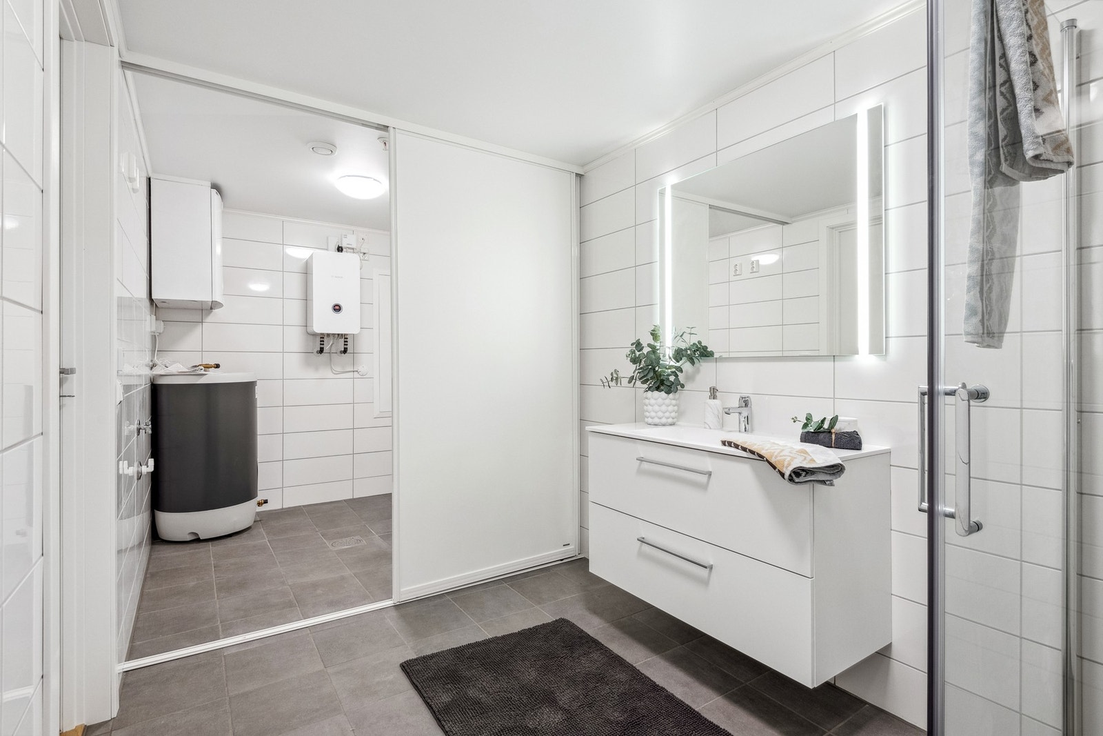 Vaskeromsdelen har man gjemt bak en skyvedør på badet. Her er det opplegg til vaskemaskin, og man kan henge opp klesvasken og skjule den bak skyvedøren. Galleribilde