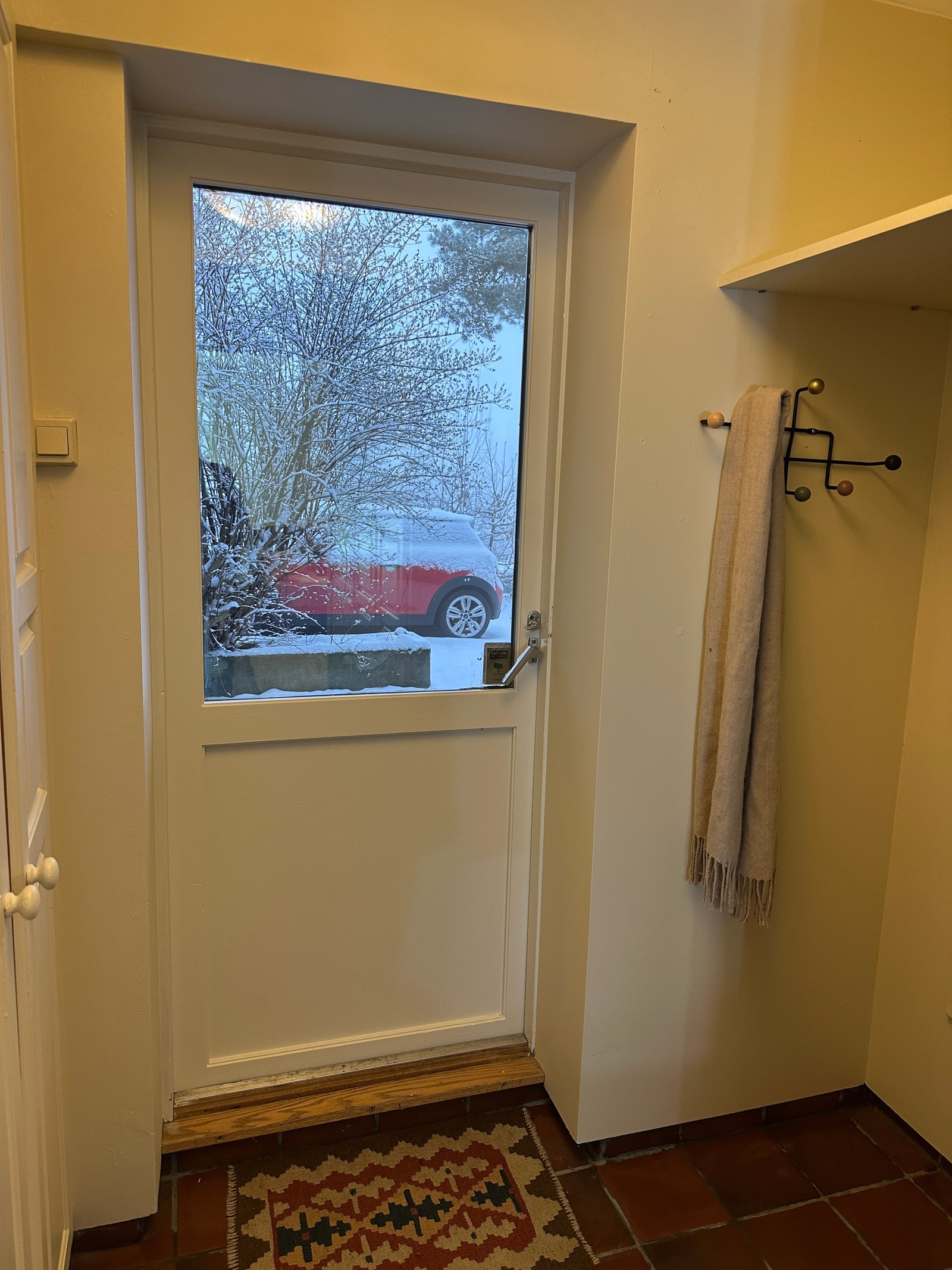 Inngangsdør med garderobe, hattehylle og speil. Galleribilde