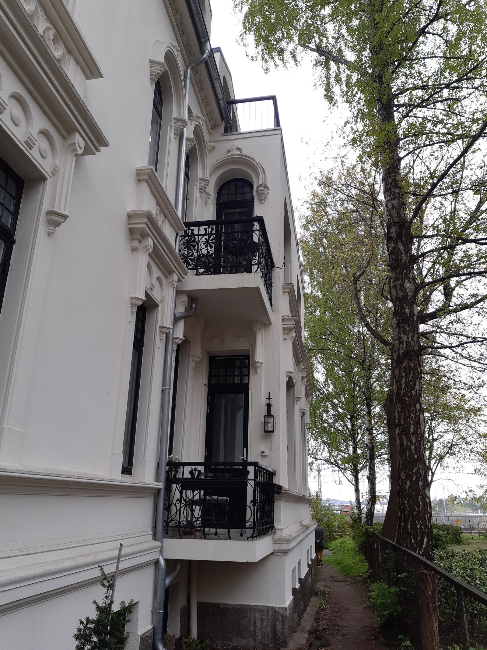 balkongen ser ut mot en liten park Galleribilde