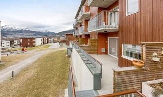 Solrik terrasse med utsikt og trapp til bakkeplan. Galleribilde