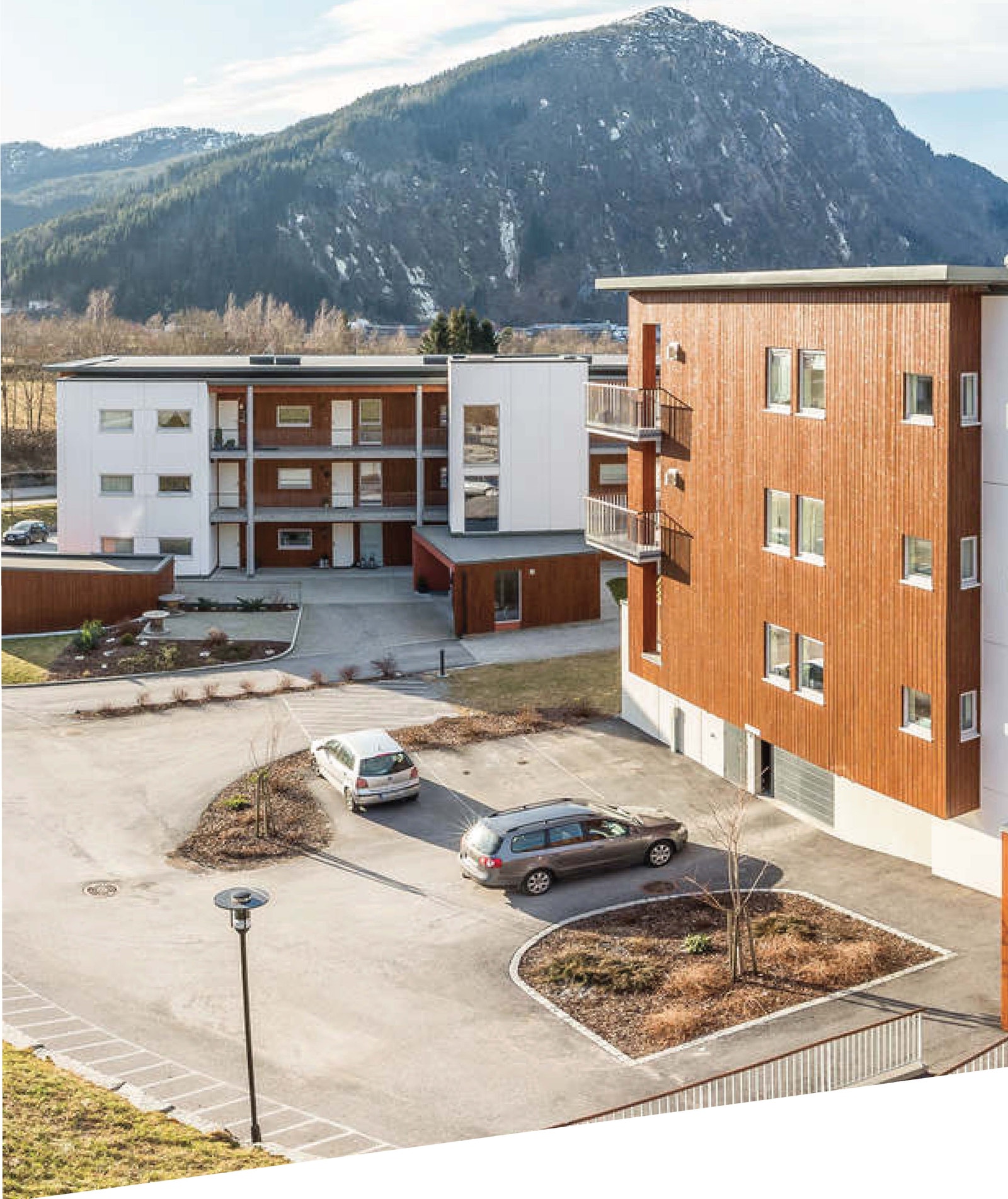 Tilkomst med port til parkeringskjellar. Sameiget sitt fellesareal er pent opparbeida med grøntareal og plantar, leikeplassar, parkeringsareal og asfalterte trafikkareal. Galleribilde