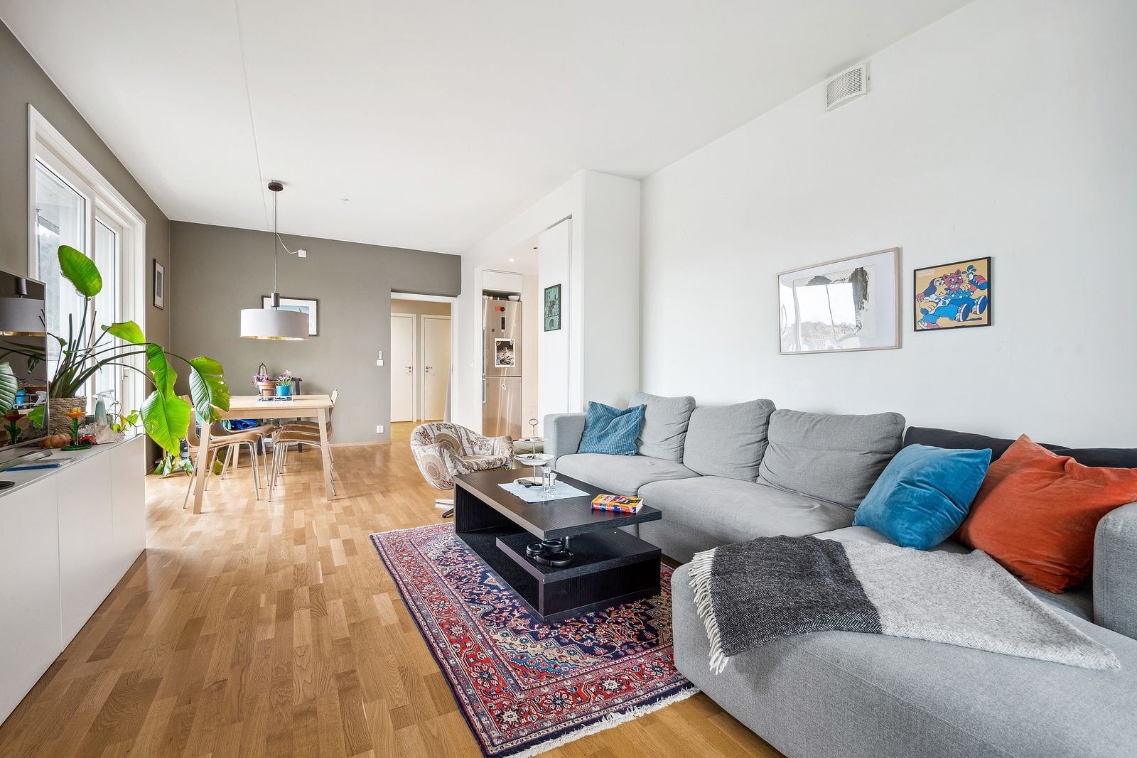 Romslig stue med stor sofa og spisebord Galleribilde