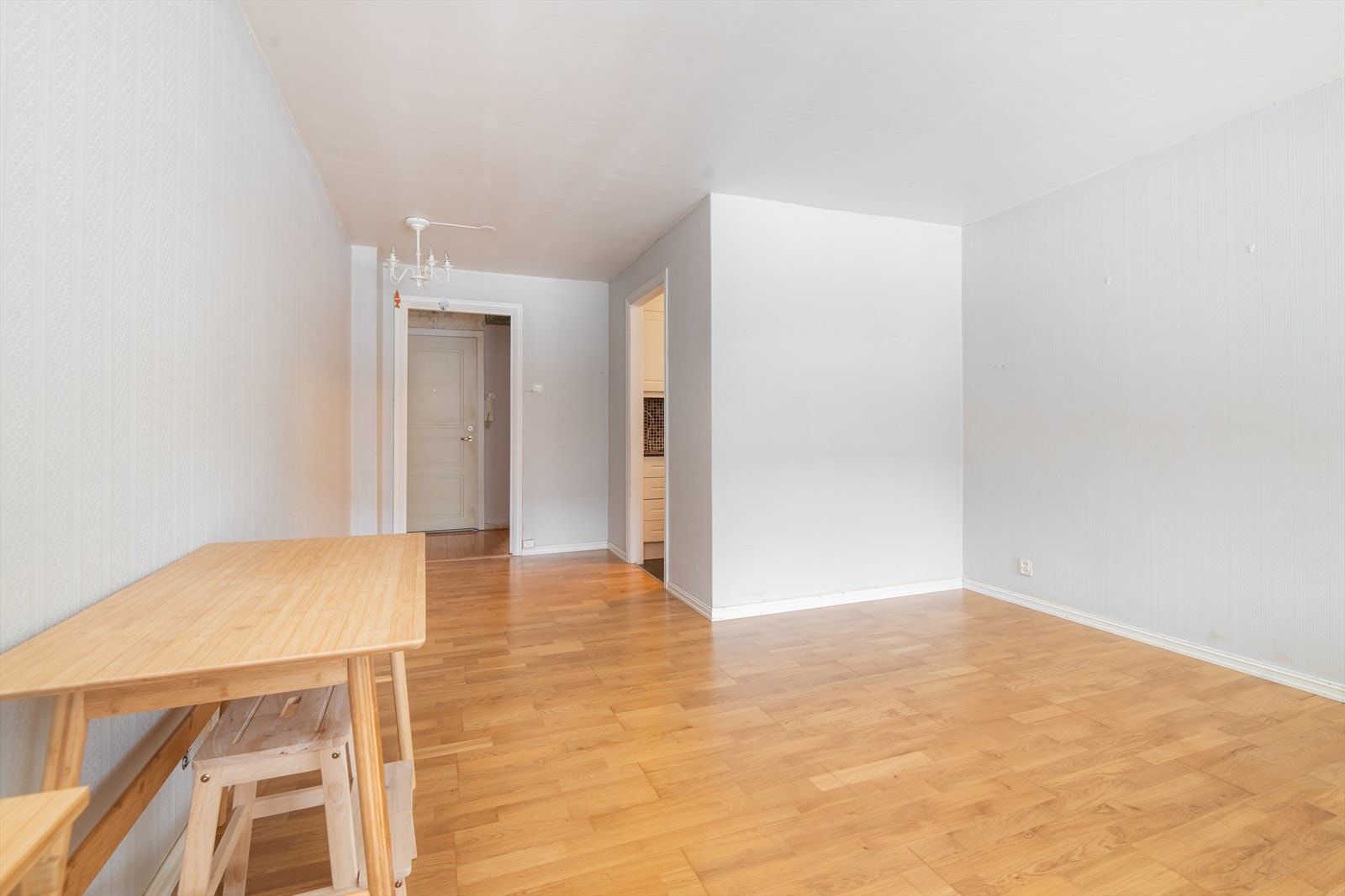 Overflater i stuen består av parkett på gulv, tapet og malt panel på vegger. Listefri overgang til malt puss i tak. Galleribilde