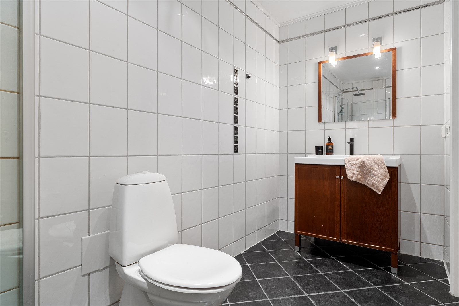 Badet er innredet med servant med møbel, dusjhjørne, wc og badekar. Galleribilde
