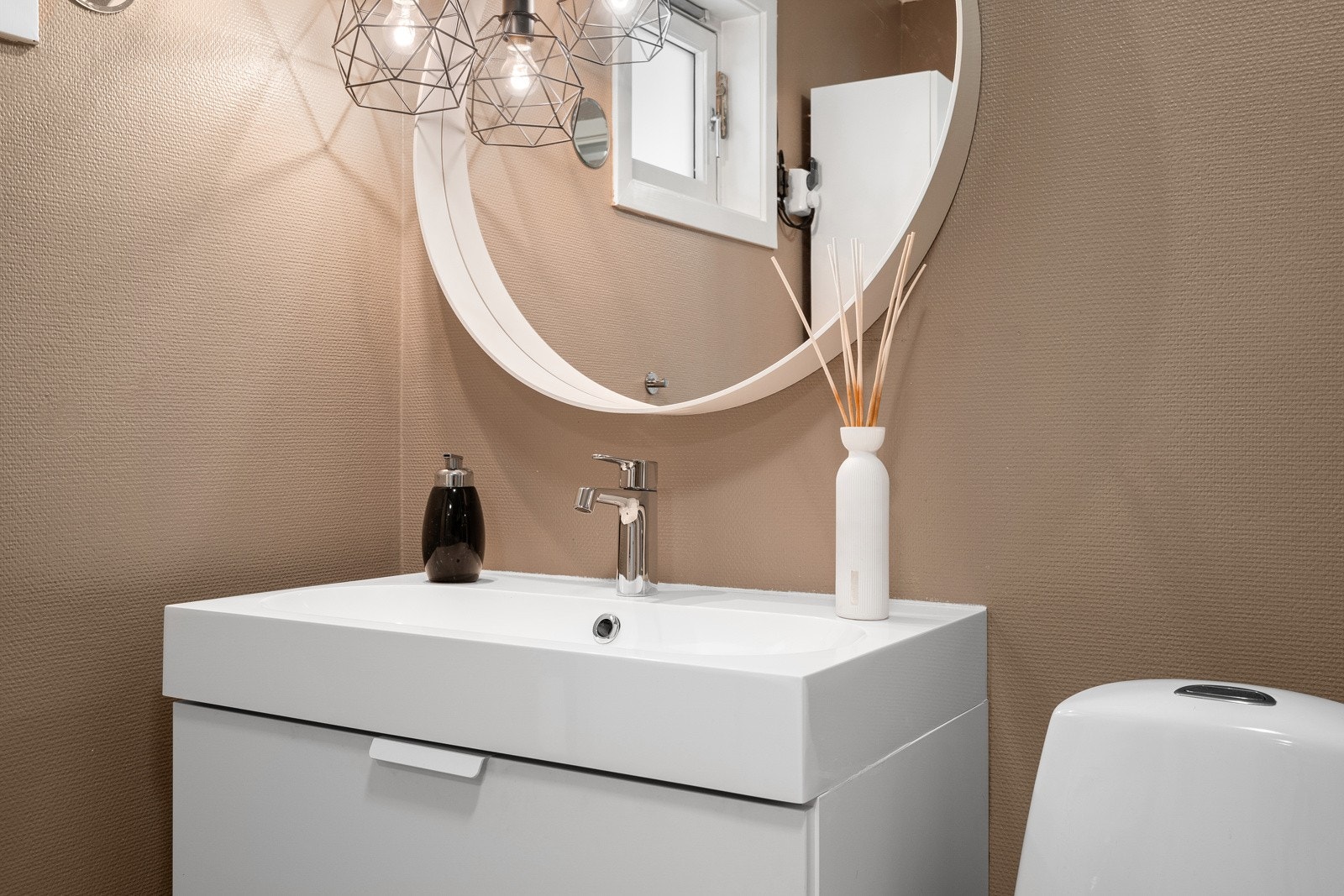 Badet har vegghengt servantinnredning og gulvstående toalett. Galleribilde