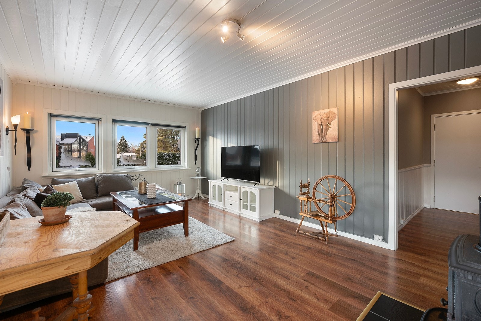 Med lyst panel i taket, en stilig kontrastvegg og et elegant mørkt gulv får du en stue som kombinerer lys og åpenhet med en varm og moderne stemning Galleribilde