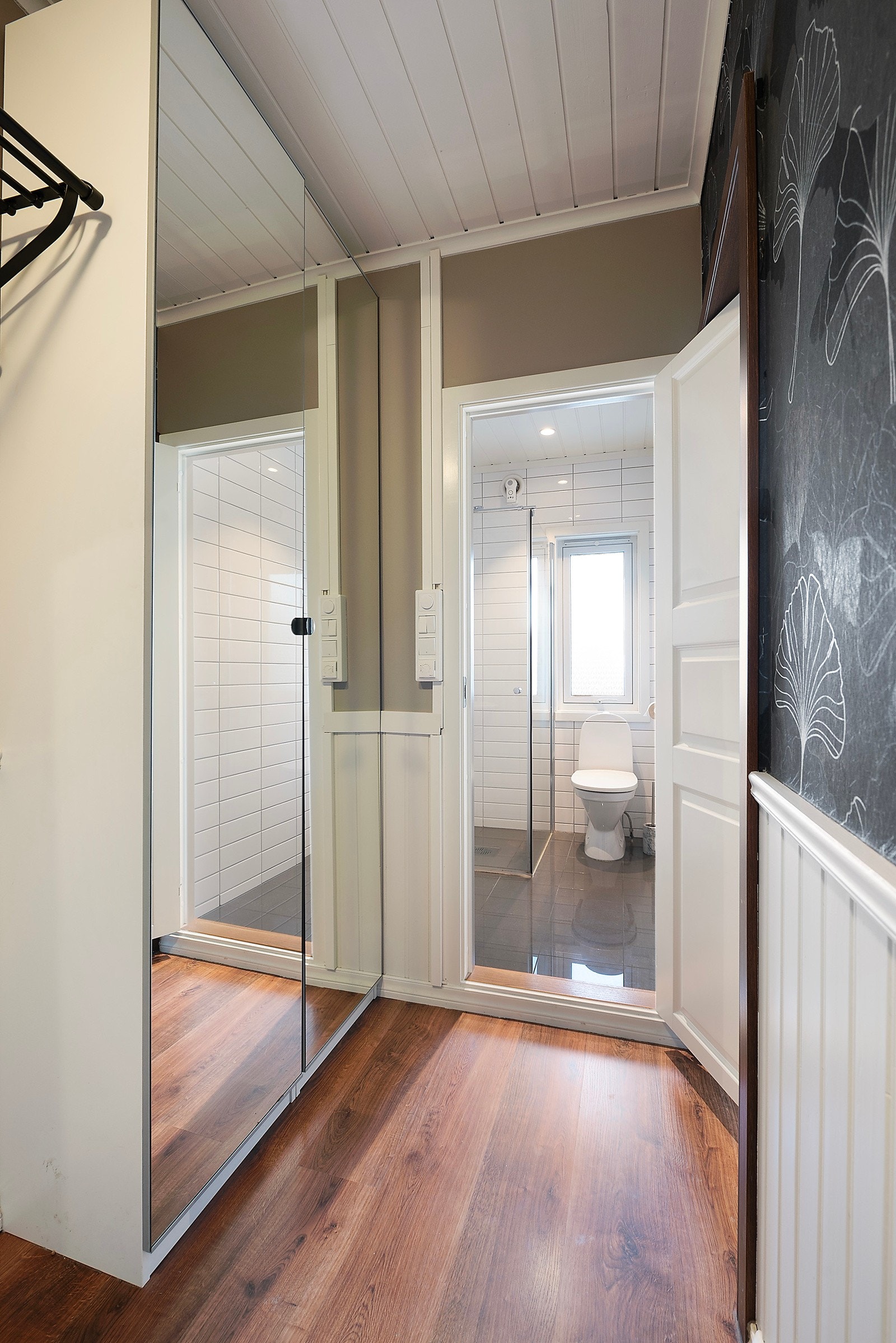 I entreen er det plass til både jakkeoppheng og et skap med speildører, som gir både funksjonalitet og et praktisk preg Galleribilde