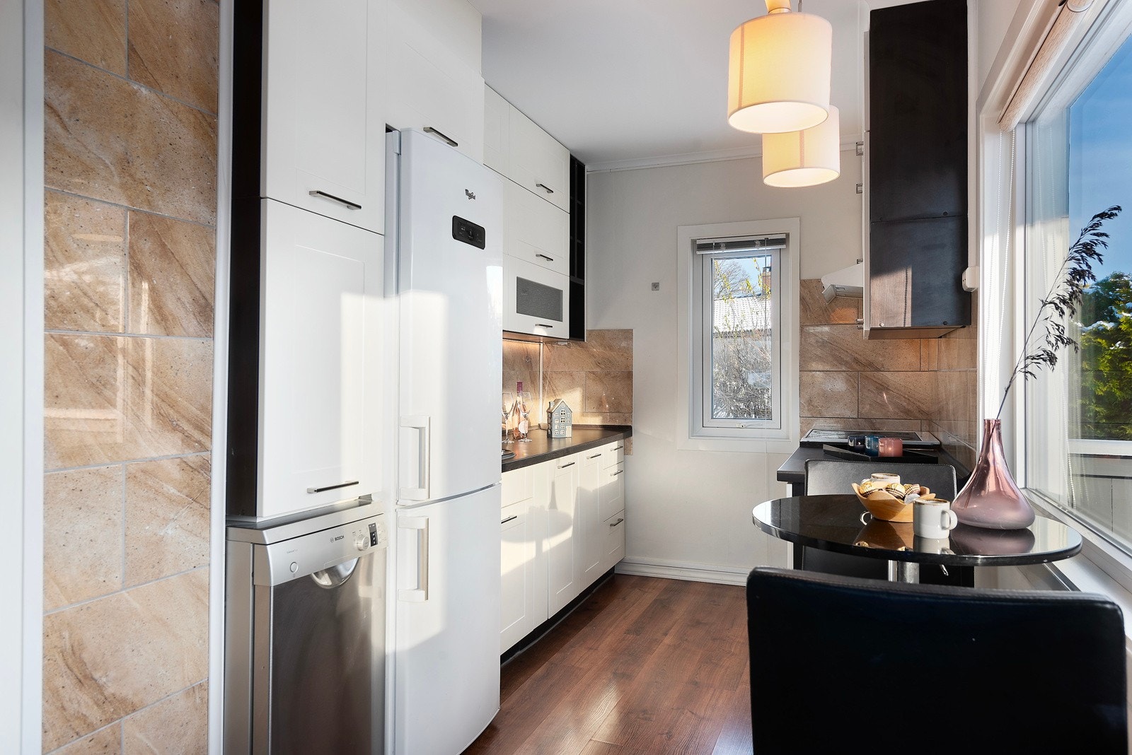 Kjøkkenet har lyse, profilerte fronter som gir et klassisk og elegant uttrykk, samt praktiske fliser mellom benkeplaten og overskapene for enkel rengjøring og et stilfullt utseende Galleribilde