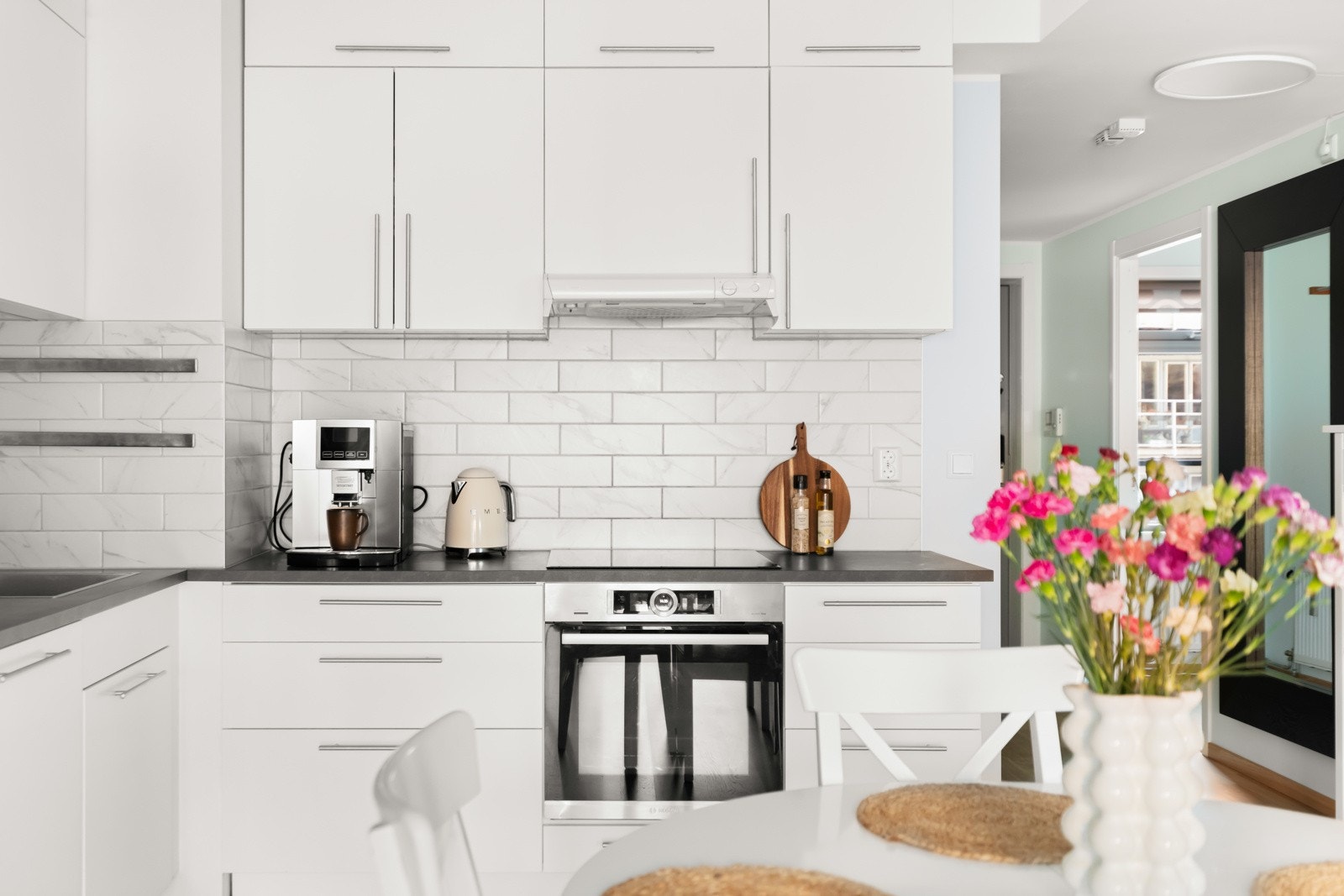 Pent kjøkken som er utstyrt med integrert stekeovn, platetopp og oppvaskmaskin, samt frittstående kjøleskap Galleribilde