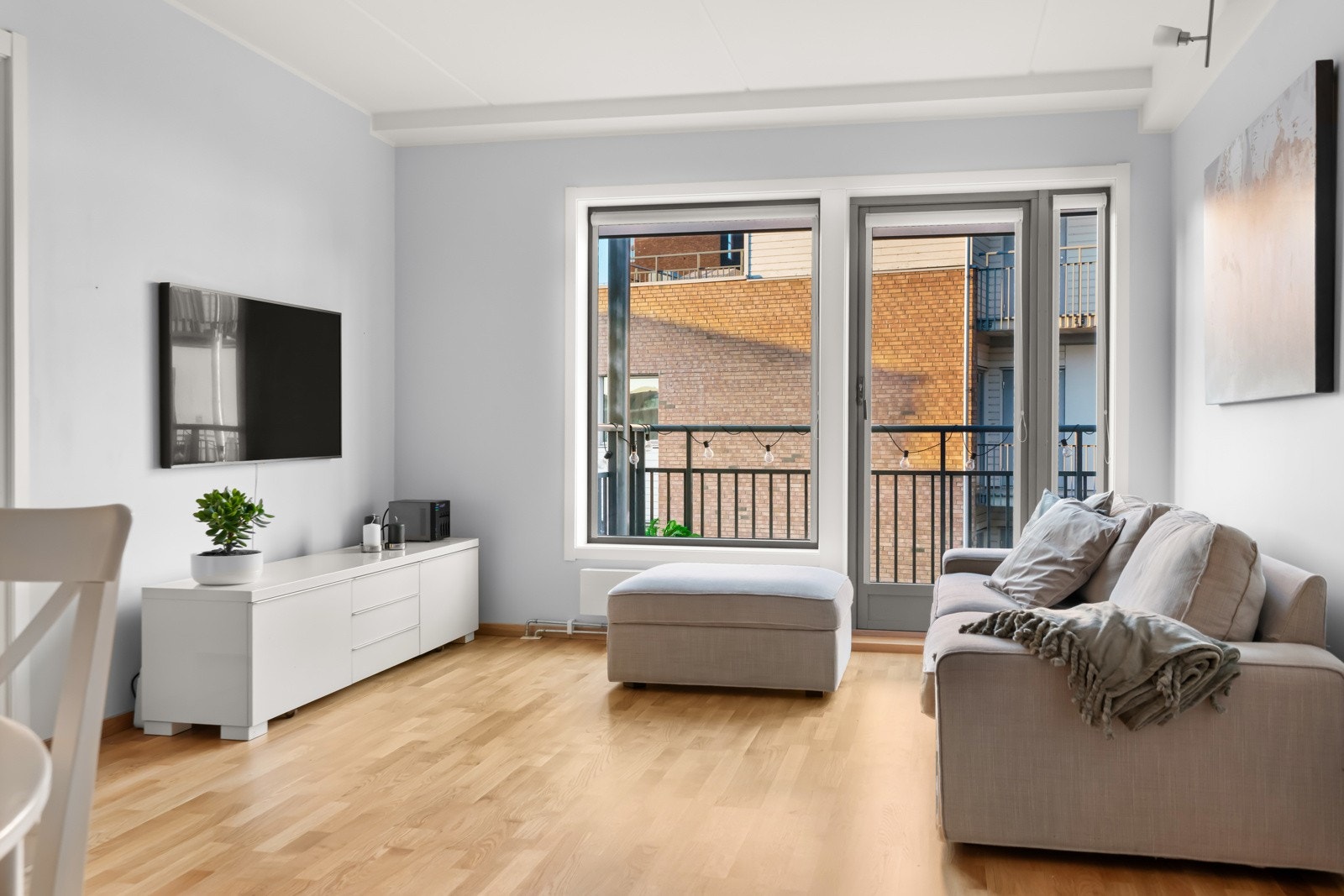 Lys stue med god plass til sofagruppe og tilhørende møblement Galleribilde