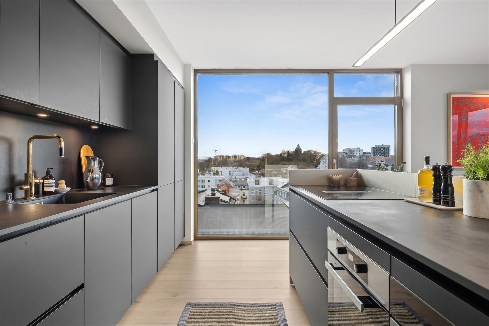 Her har man et moderne og stilsikkert kjøkken med integrerte hvitevarer Galleribilde