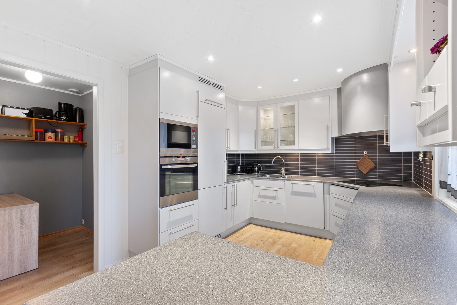 Kjøkkeninnredning med lyse slette overflater, godt med skuffer og skap og god benkeplass, det er montert vannstoppsystem. Galleribilde