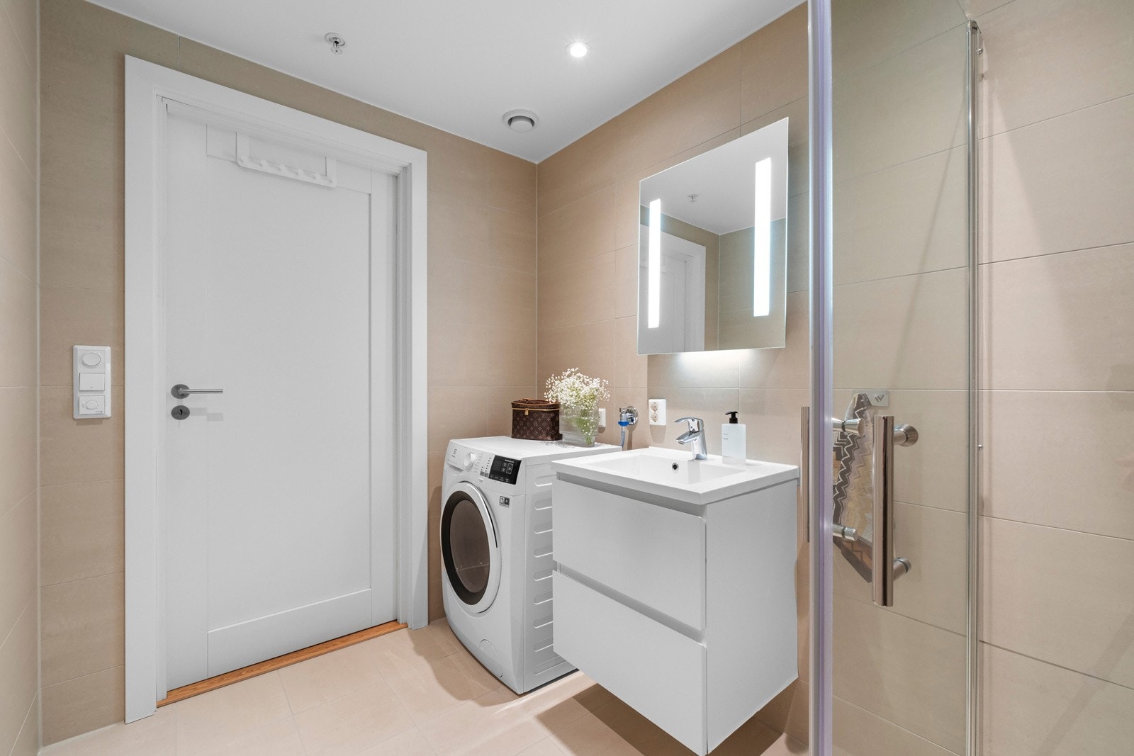 Badet er utstyrt med dusjnisje med glassdører, vegghengt toalett og servant med innredning. Avtrekk på bad via balansert ventilasjonsanlegg. Galleribilde