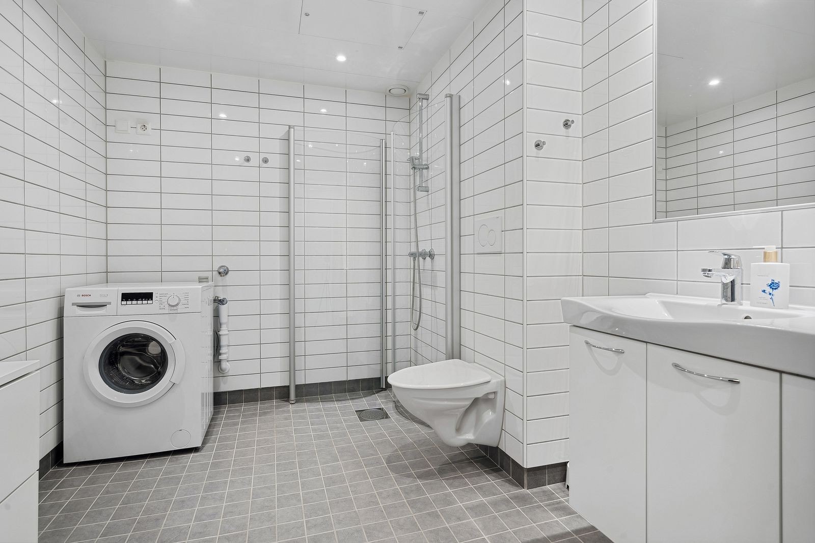 Lyst og pent flislagt bad med innfellbare dusjdører - Vaskemaskin medfølger Galleribilde