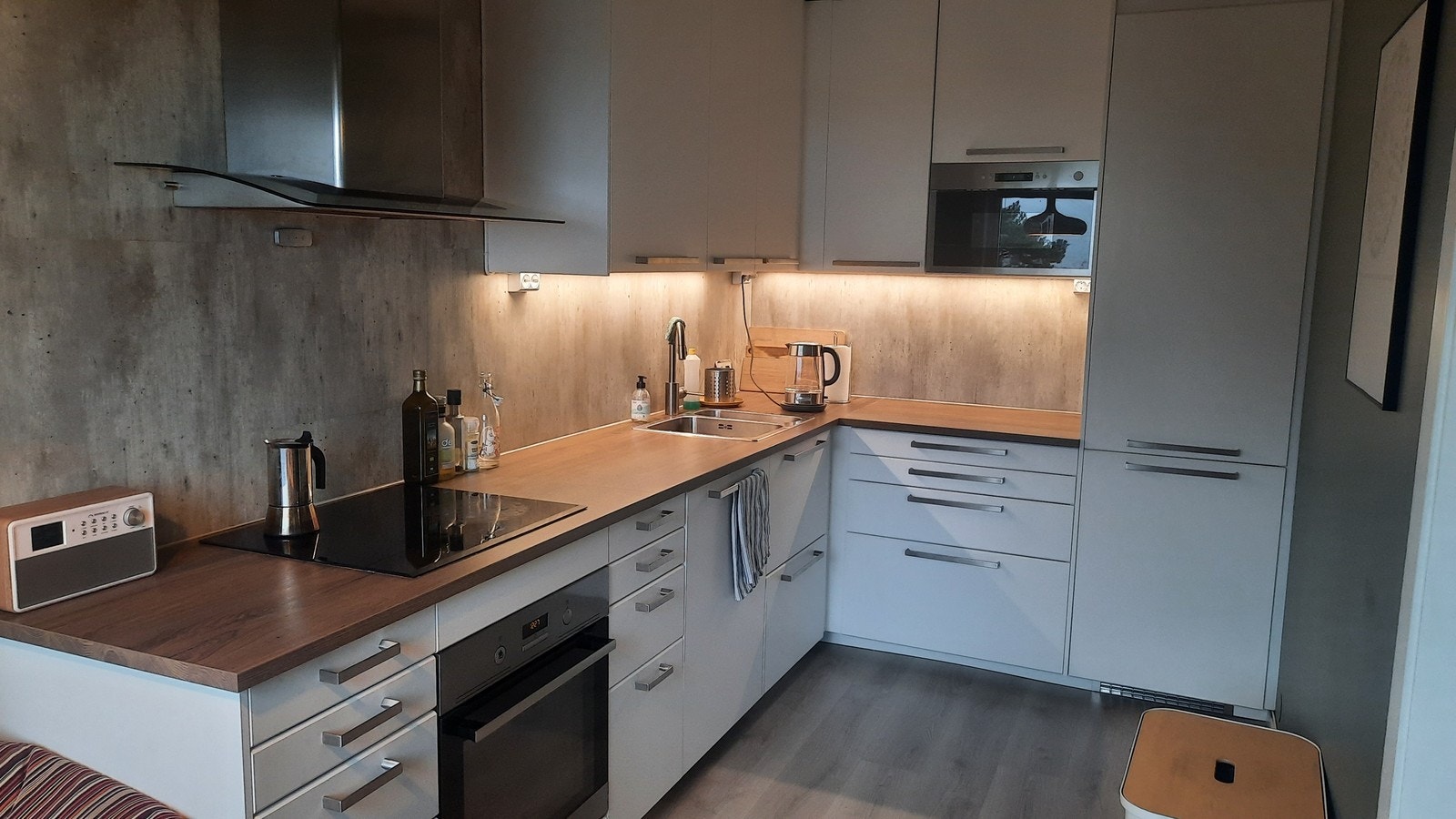 Pent kjøkken med godt med skap og benkeplass samt integrerte hvitevarer Galleribilde