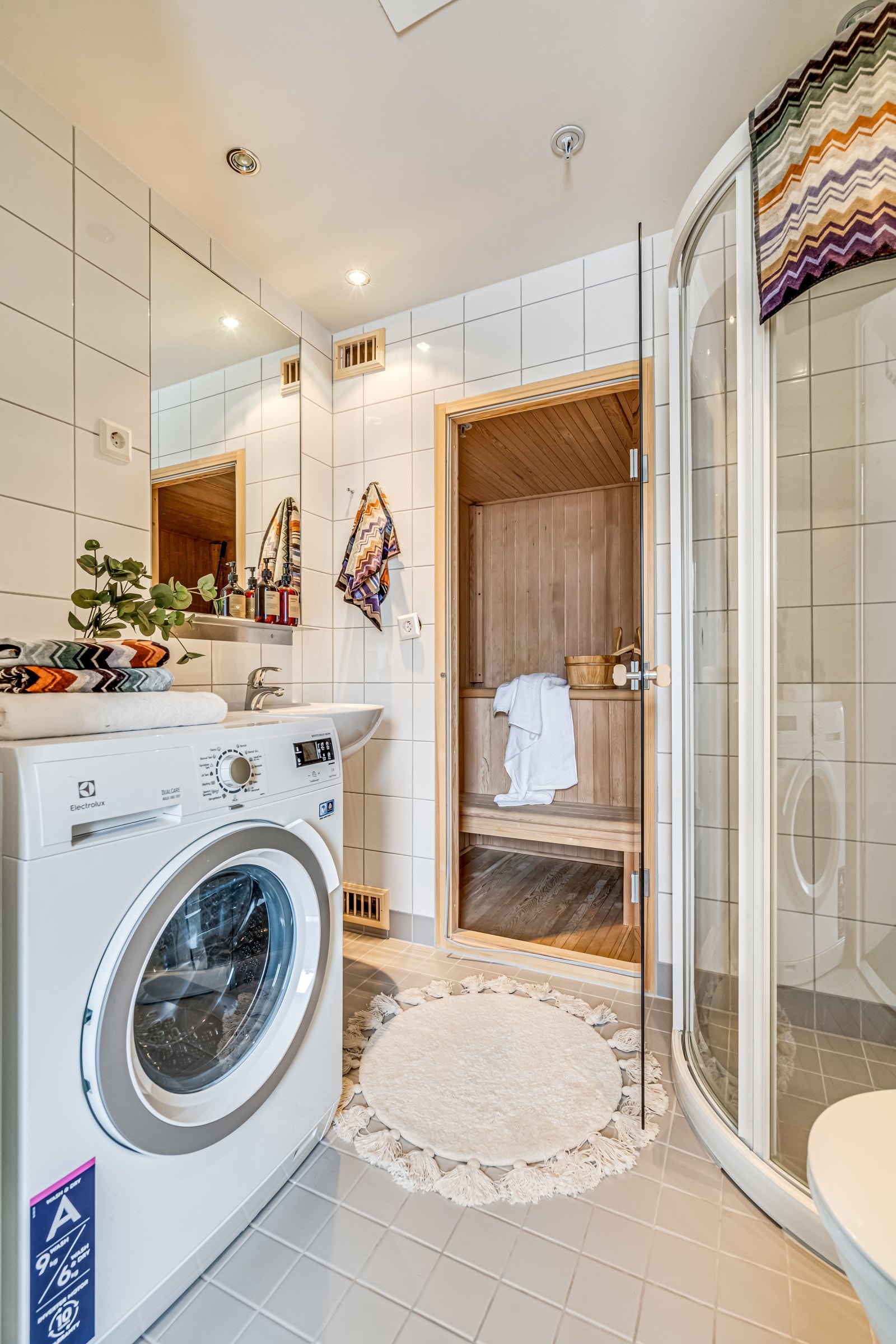 Innredet med servant, vegghengt toalett, dusjhjørne og opplegg for vaskemaskin. Galleribilde