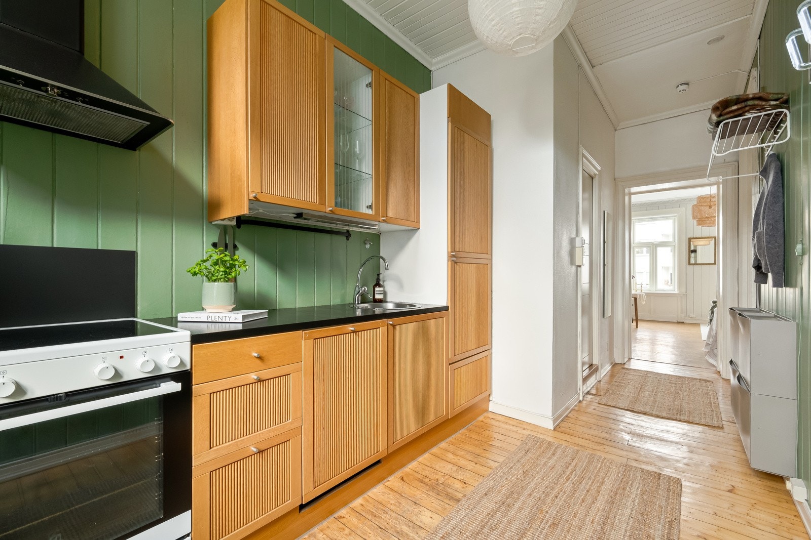 Kjøkkeninnredning består av profilerte trefronter med knotter, benkeplater i heltre, stålkum med blandebatteri, integrert kjøl/frys, oppvaskmaskin og plass til komfyr. Galleribilde