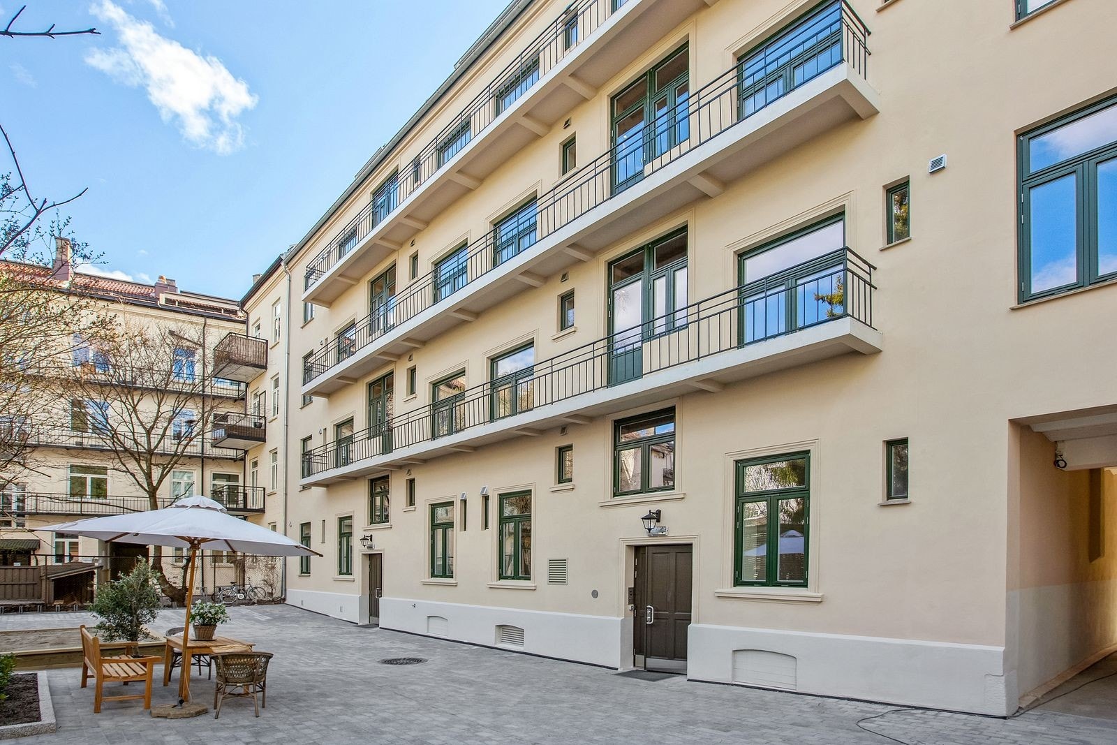 Bakgård med sittegruppe, sykkelparkering og felles brannbalkonger Galleribilde