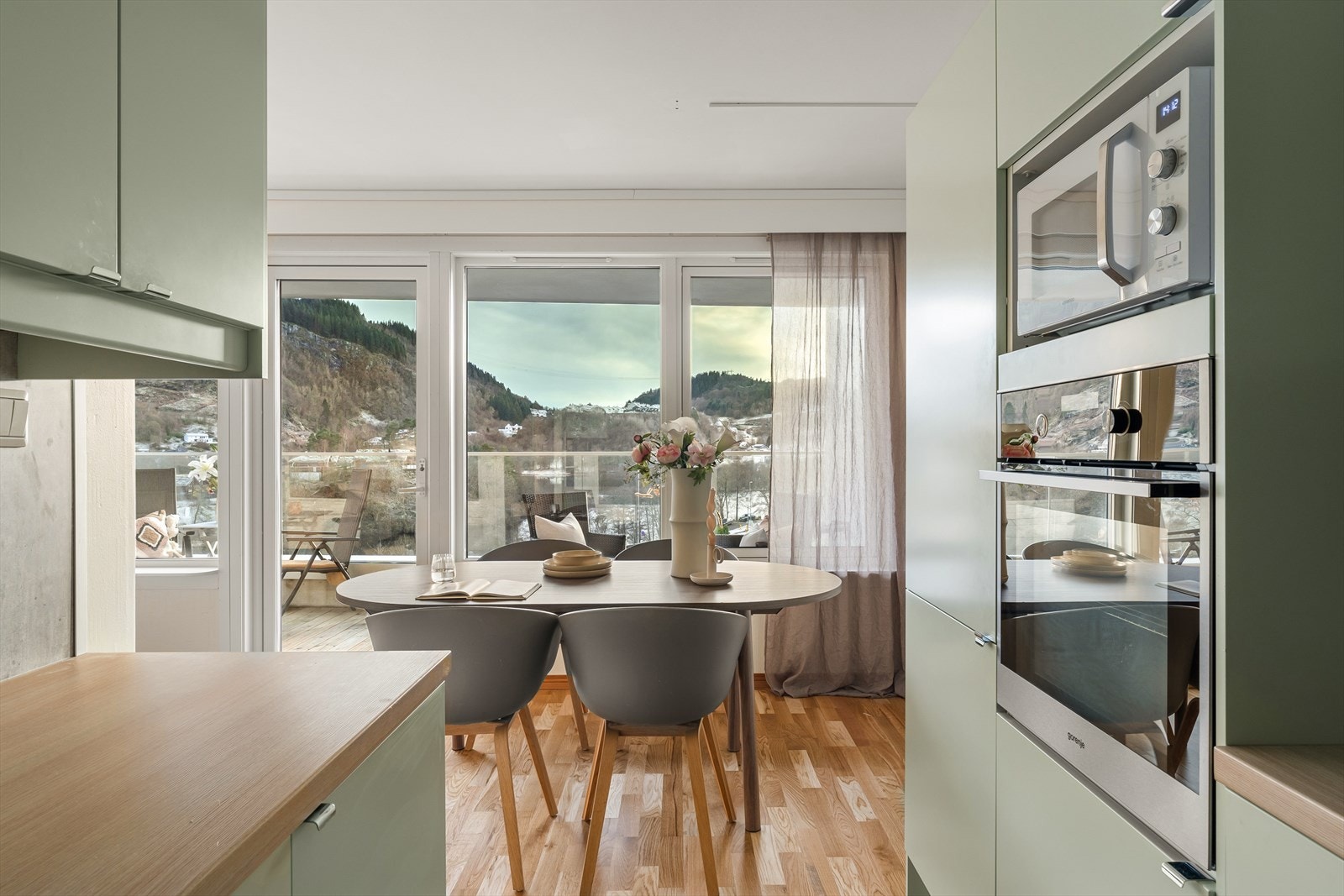 Store vindusflater gir oppholdsrommet et nydelig lysinnslipp. Både vinduer og terrassedør ble skiftet i 2021. Galleribilde