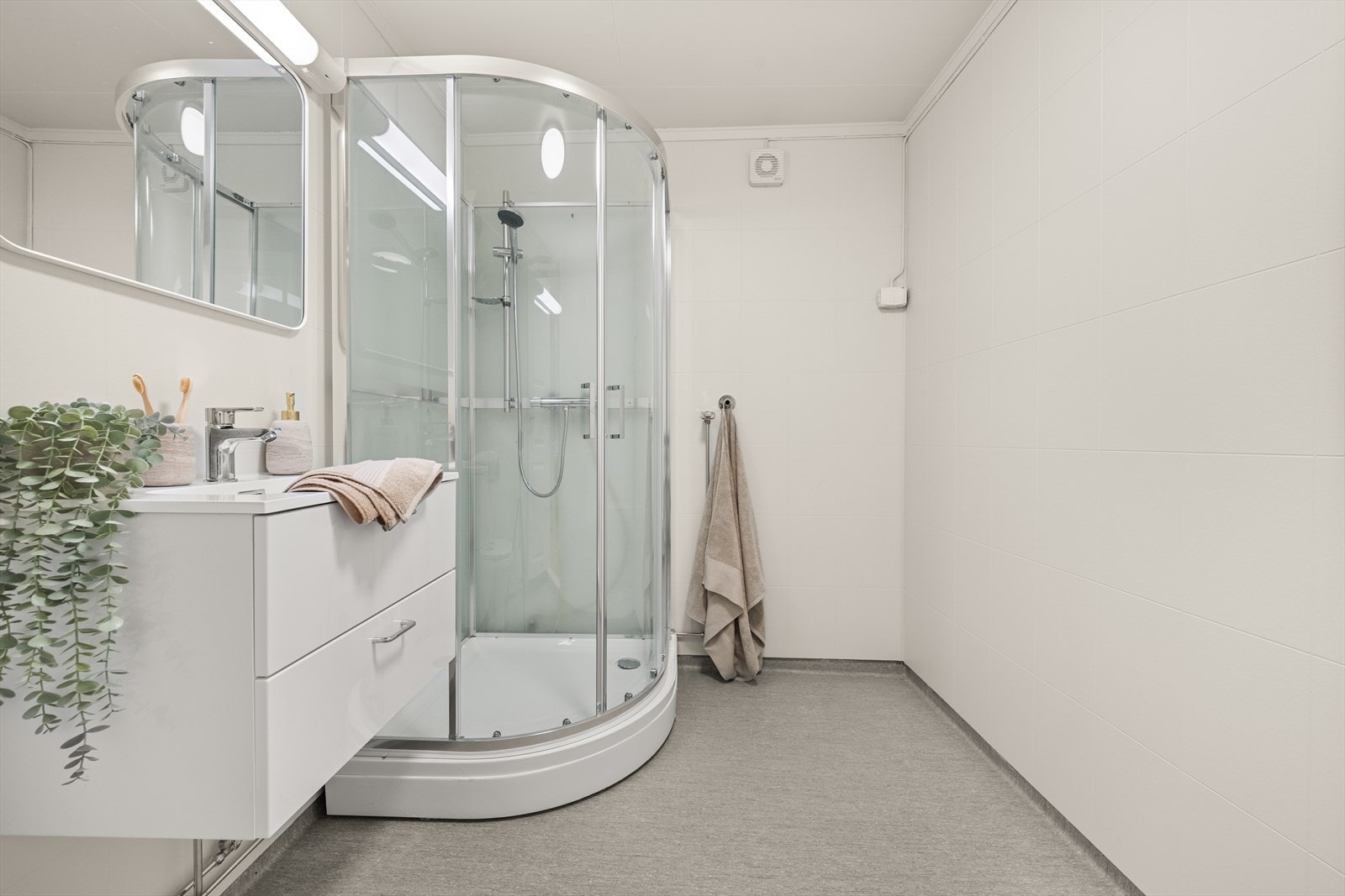 Romslig bad med belegg på gulv og våtromsplater på vegg Galleribilde