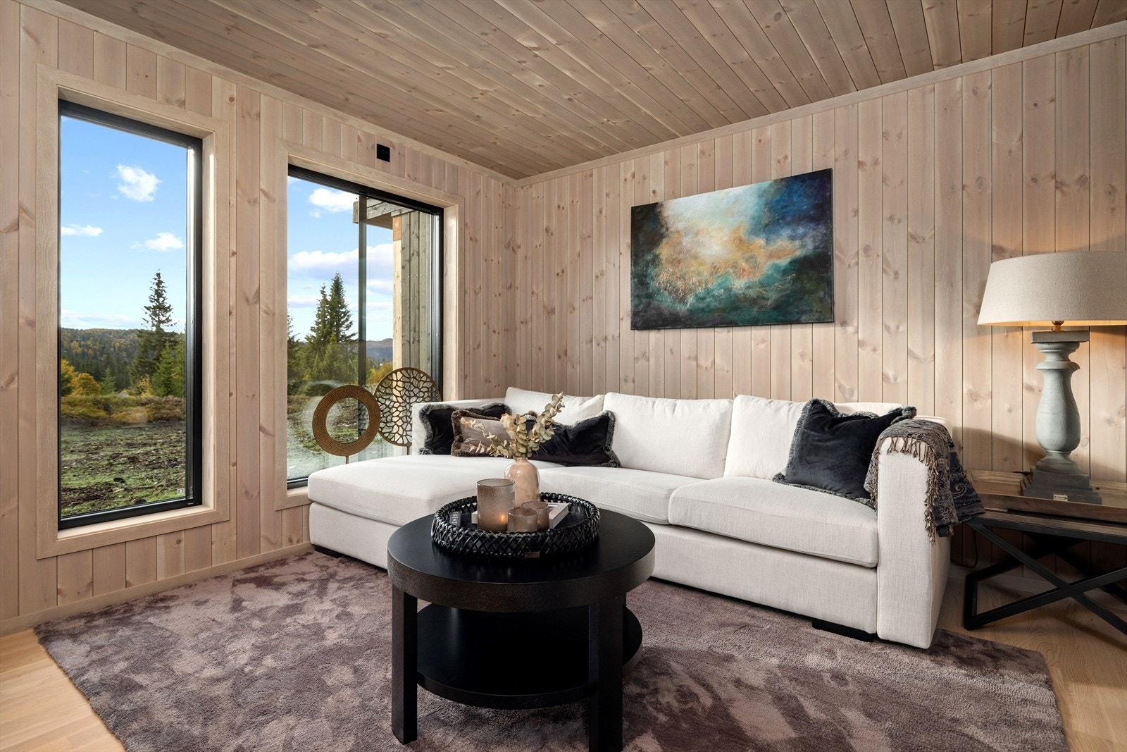 Stuen har store vindusflater og fin utsikt mot nærliggende grøntområder. Galleribilde