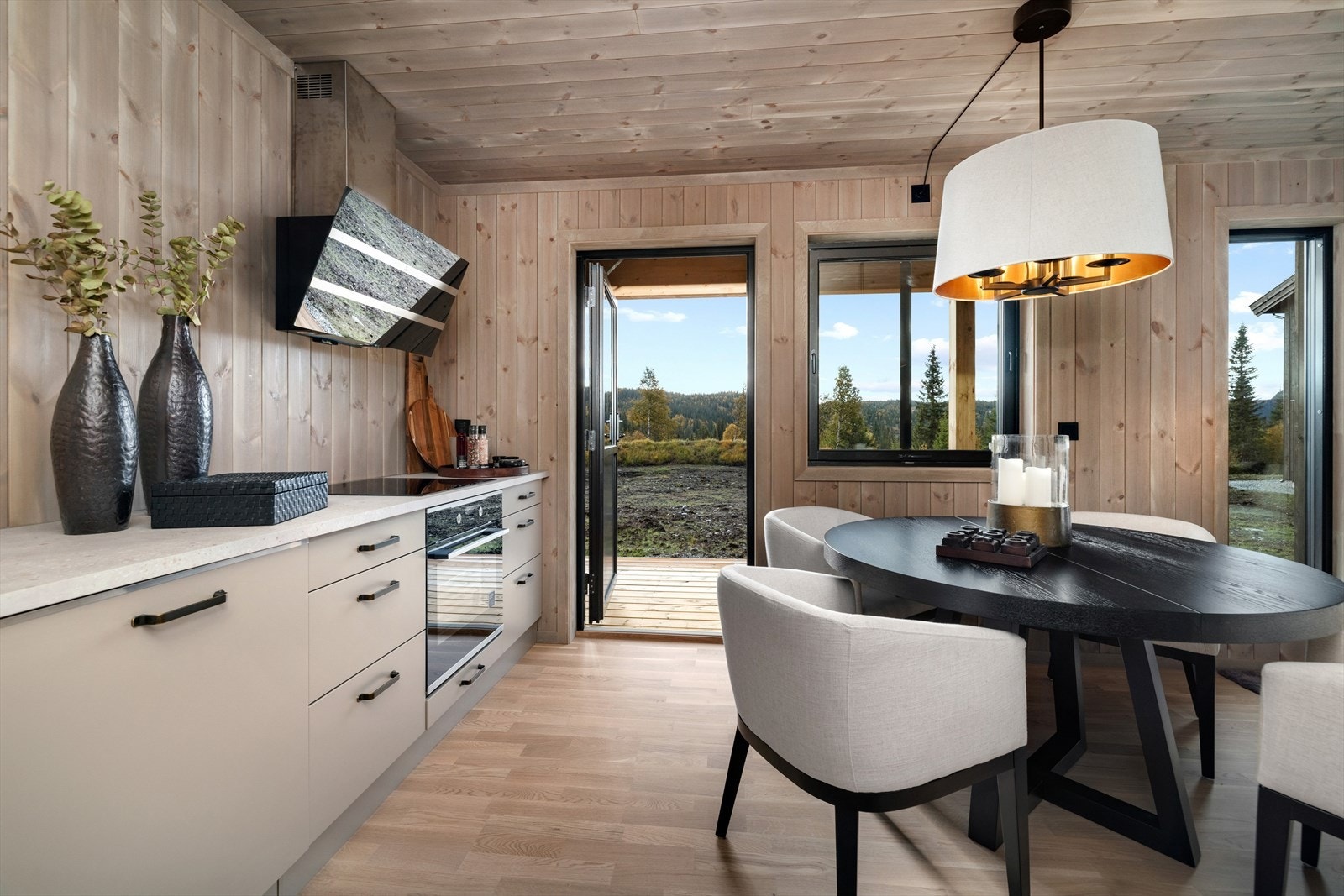 Kjøkkenet er utstyrt med integrert oppvaskmaskin, stekeovn og platetopp. Fritthengende moderne ventilator over platetopp. Galleribilde