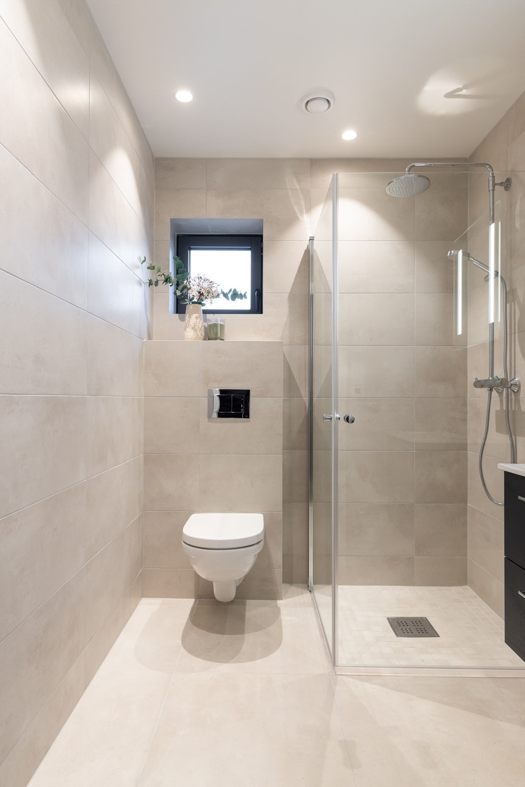 Badet er utstyrt med vegghent WC med dempesete, servantinnredning fra Korsbakken, speil med integrert lys over servant og dusjvegger fra Viking bad med regnfallsdusj og hånddusj. Galleribilde