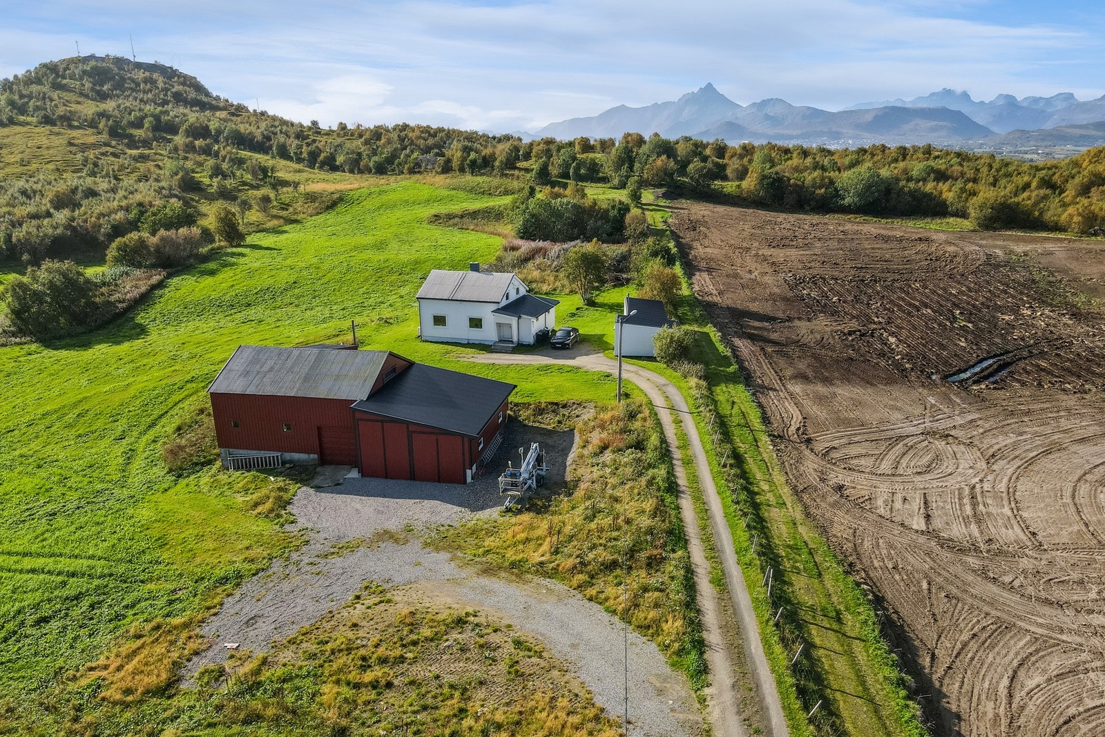 Eiendommen ligger innerst i en blindvei, sentralt, men tilbaketrukket. Gruset parkeringsområde, naturtomt og noe plen. Galleribilde
