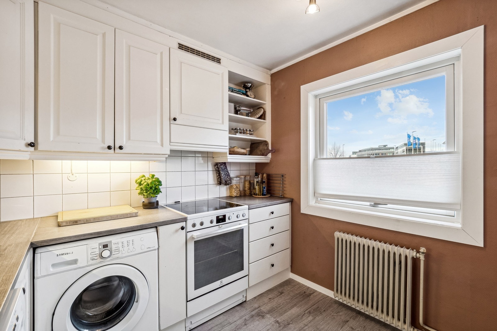 Kjøkkenet har innredning med profilerte fronter og benkeplate i laminat Galleribilde