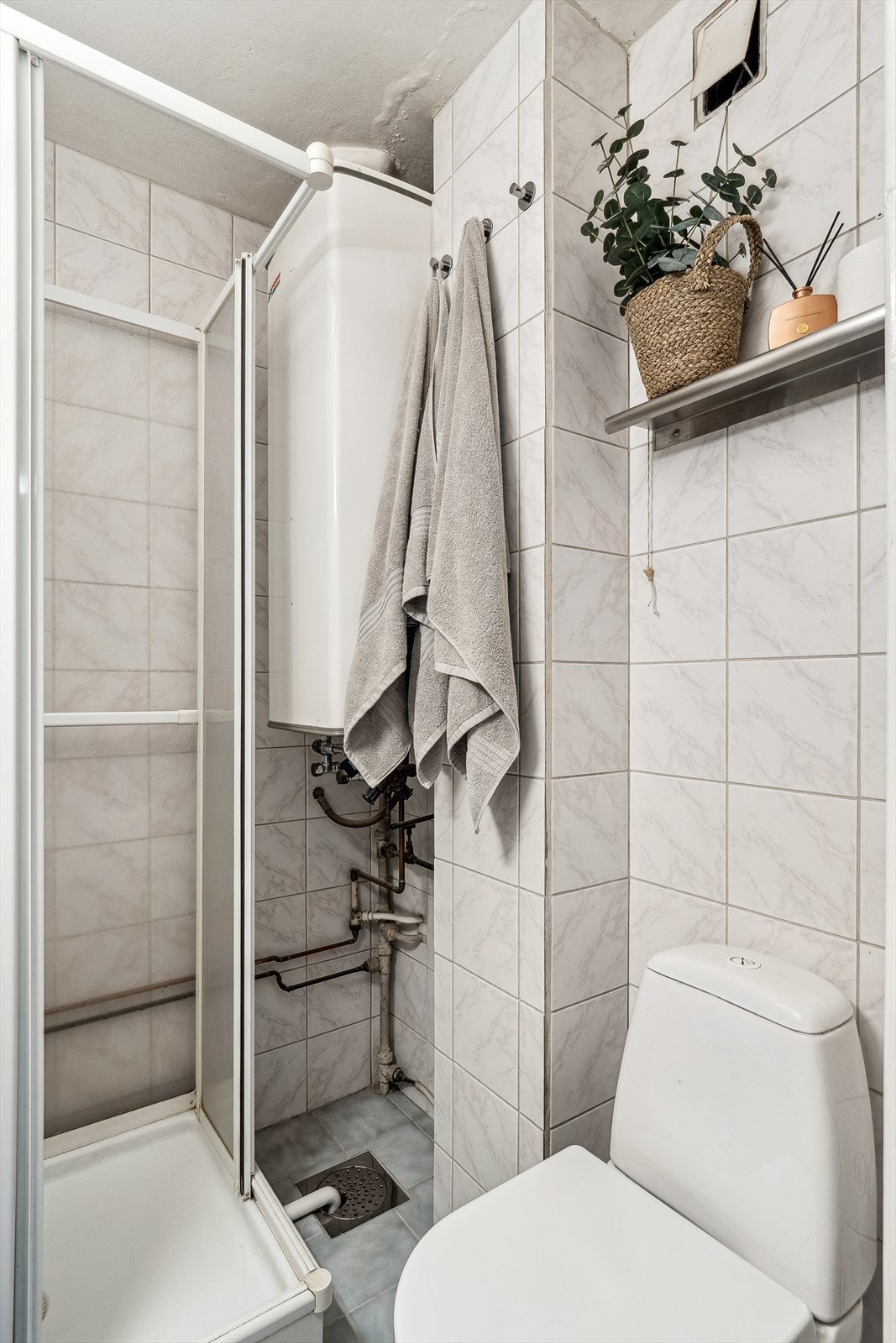 Badet har innredning med nedfelt servant, toalett og dusjkabinett Galleribilde