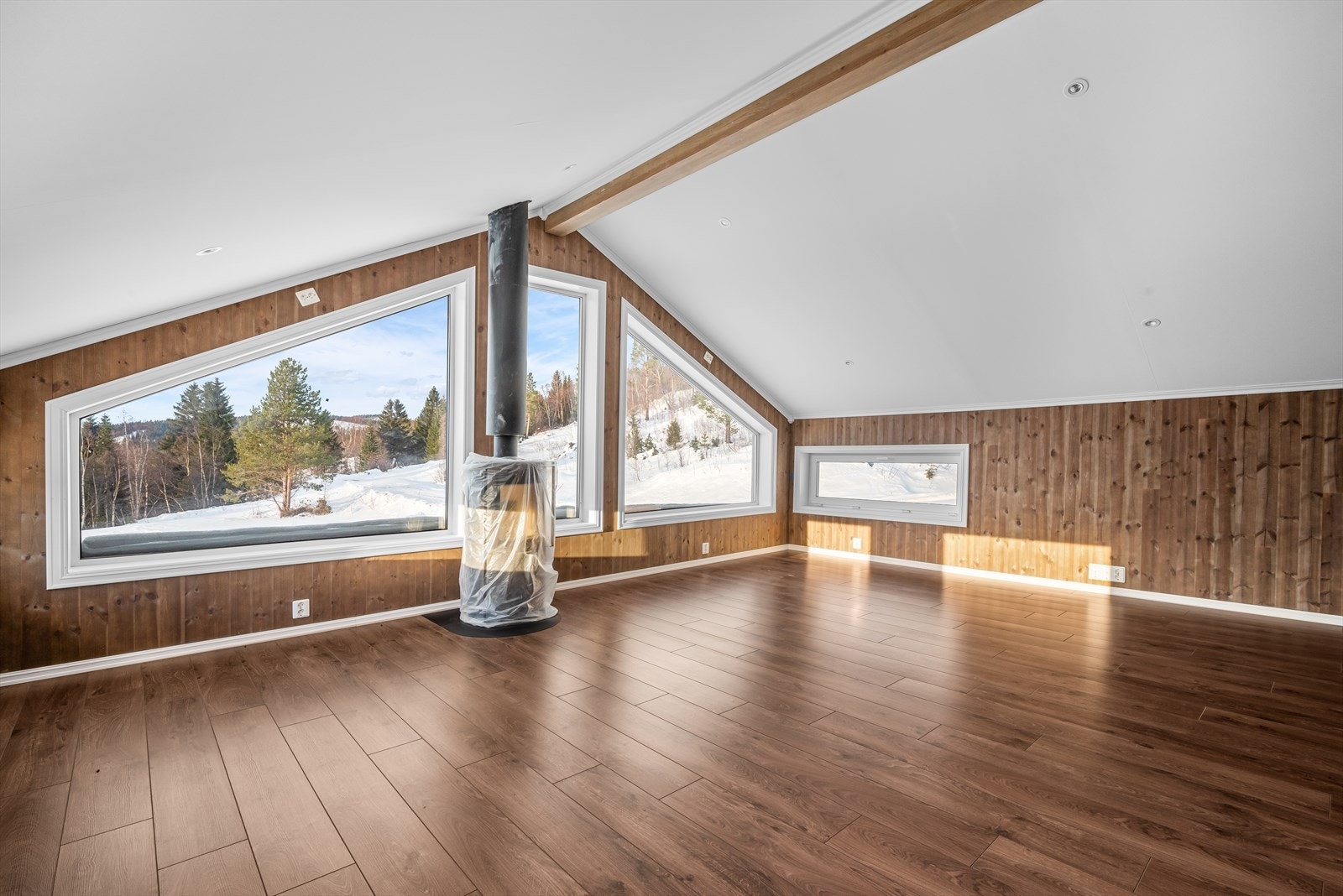 I loftstuen er det installert en elegant peisovn, som ikke bare sørger for energieffektiv oppvarming, men også skaper en varm og koselig atmosfære Galleribilde