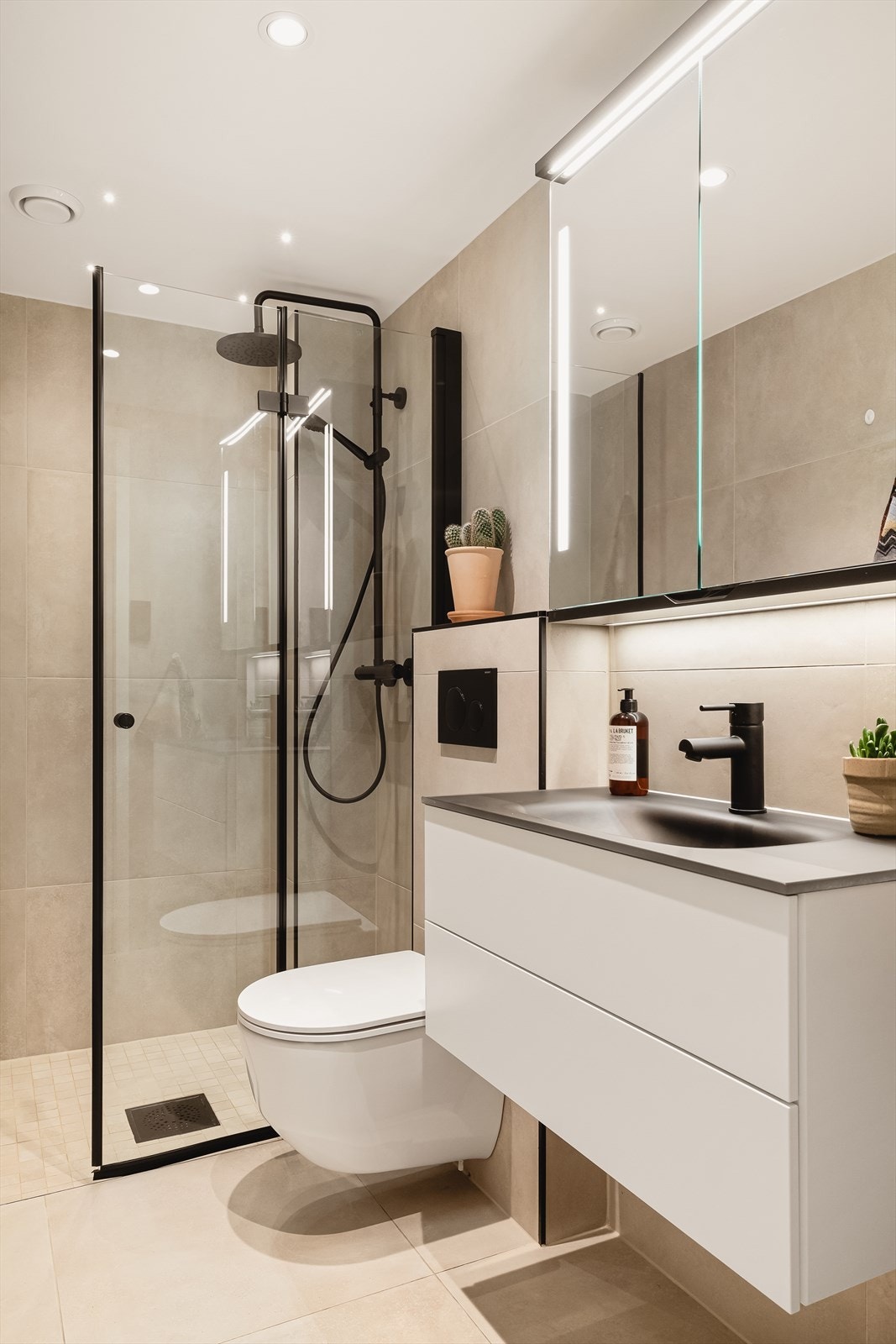 Her er spotter i tak, speilskap med overlys og stikkontakt, vegghengt dusjarmatur og vegghengt toalett. Vannrør av typen rør-i-rør system. Galleribilde