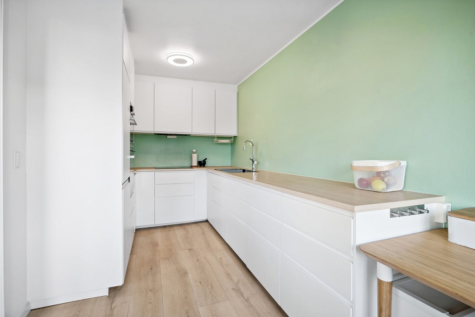 Delvis åpen løsning inn til et moderne kjøkken med integrerte hvitevarer Galleribilde