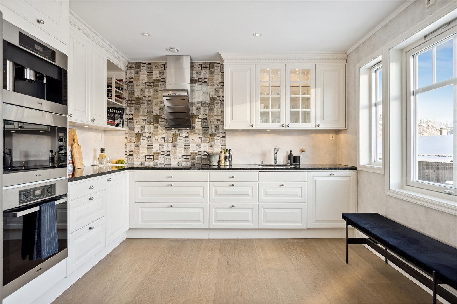 Kjøkkeninnredning med mekanisk avtrekksvifte over stekesonen. Galleribilde