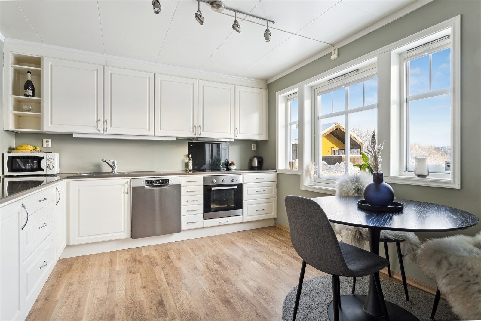 Kjøkkeninnredning med mekanisk avtrekksvifte over stekesonen og opplegg for vaskemaskin. Det er integrert stekovn og platetopp. TG-1 fra takstmann. Galleribilde