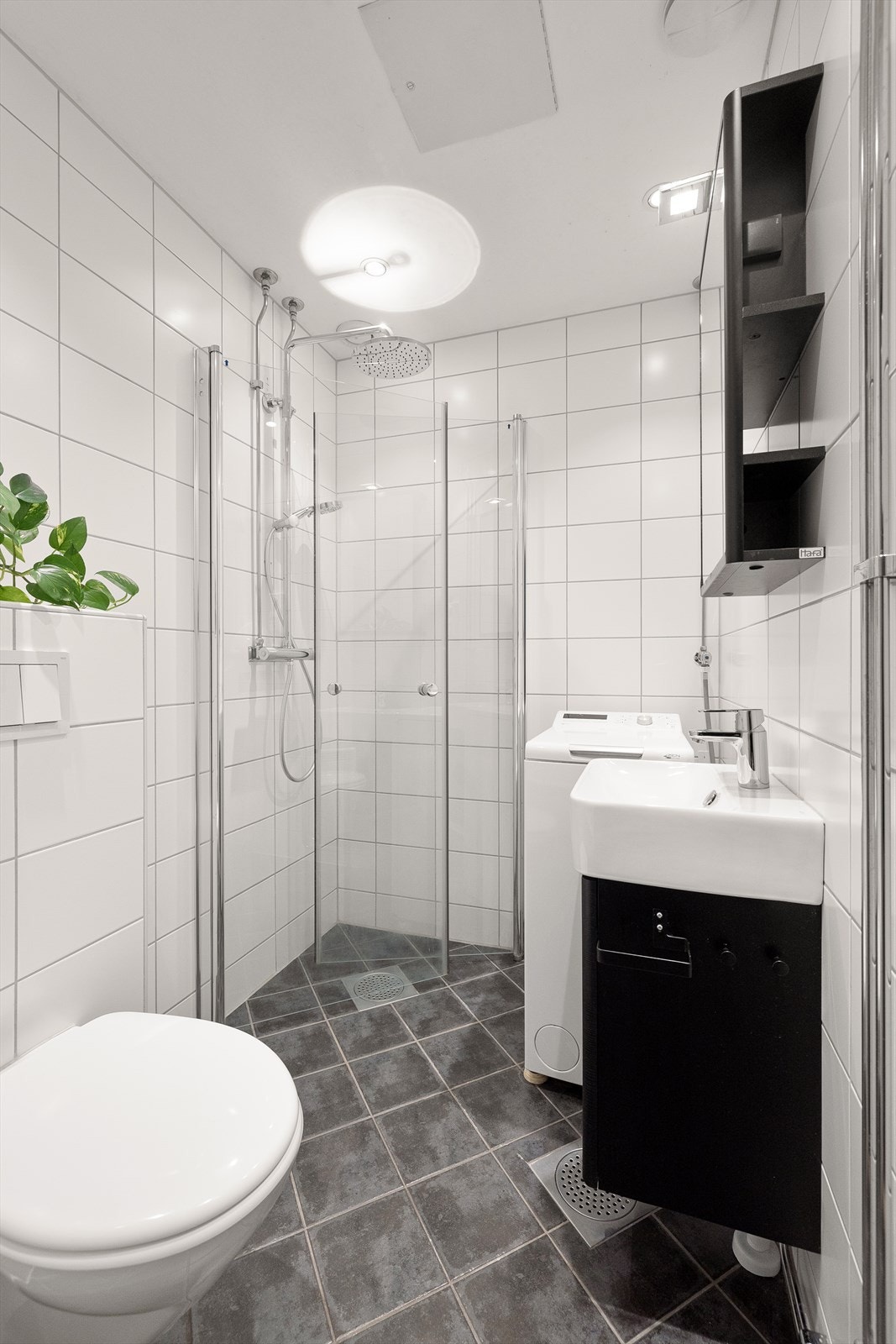 Pent og delikat bad fra 2015 med flislagte overflater, gulvvarme og opplegg for vaskemaskin. Badet ligger utenfor boenheten. Galleribilde