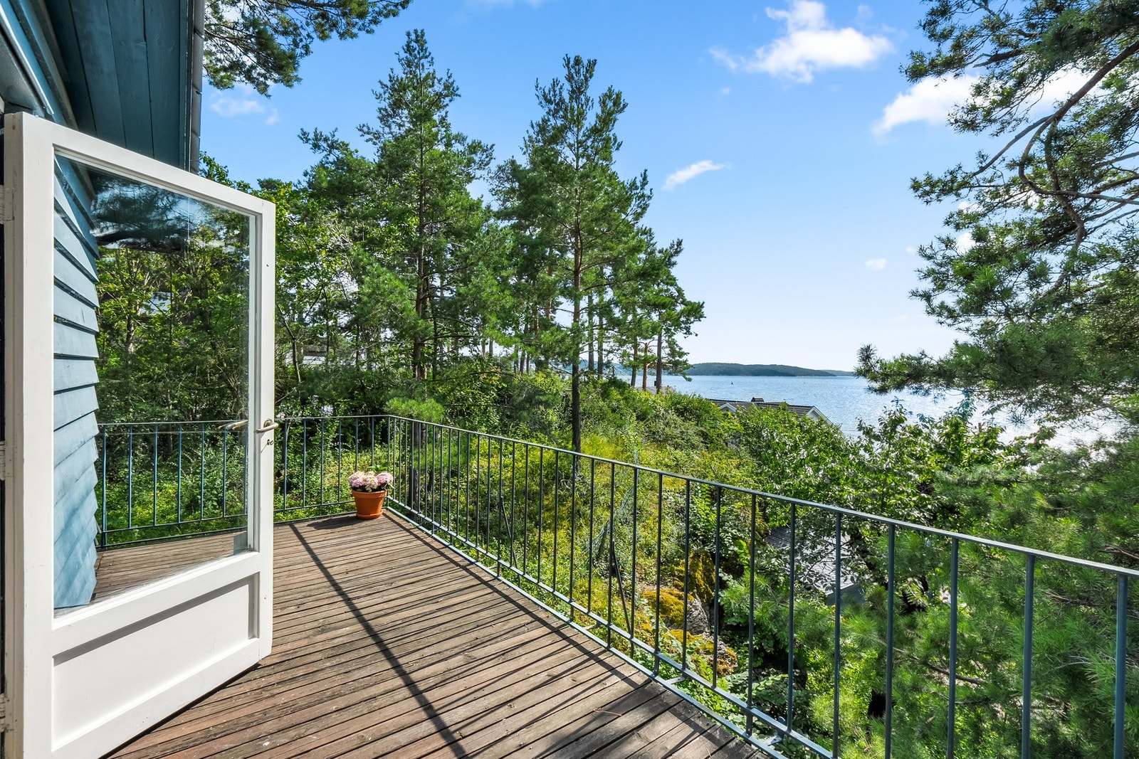 Stuen i 1. etasje forlenges av en stor balkong med vakker utsikt over fjorden. (Mange av trærne i front er kuttet/fjernet i etterkant av foto) Galleribilde