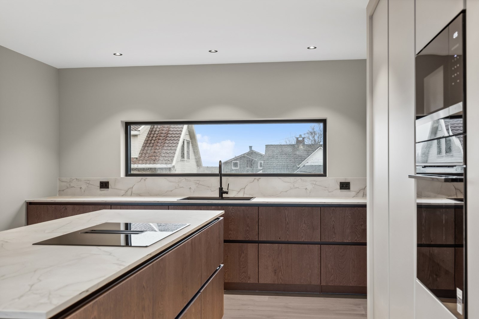 Kjøkkenet er utstyrt med integrerte hvitevarer og en åpen hylle som binder kjøkkenet mot stue for det lille ekstra. Det er rikelig med oppbevaring i høyskap og underskap. Galleribilde