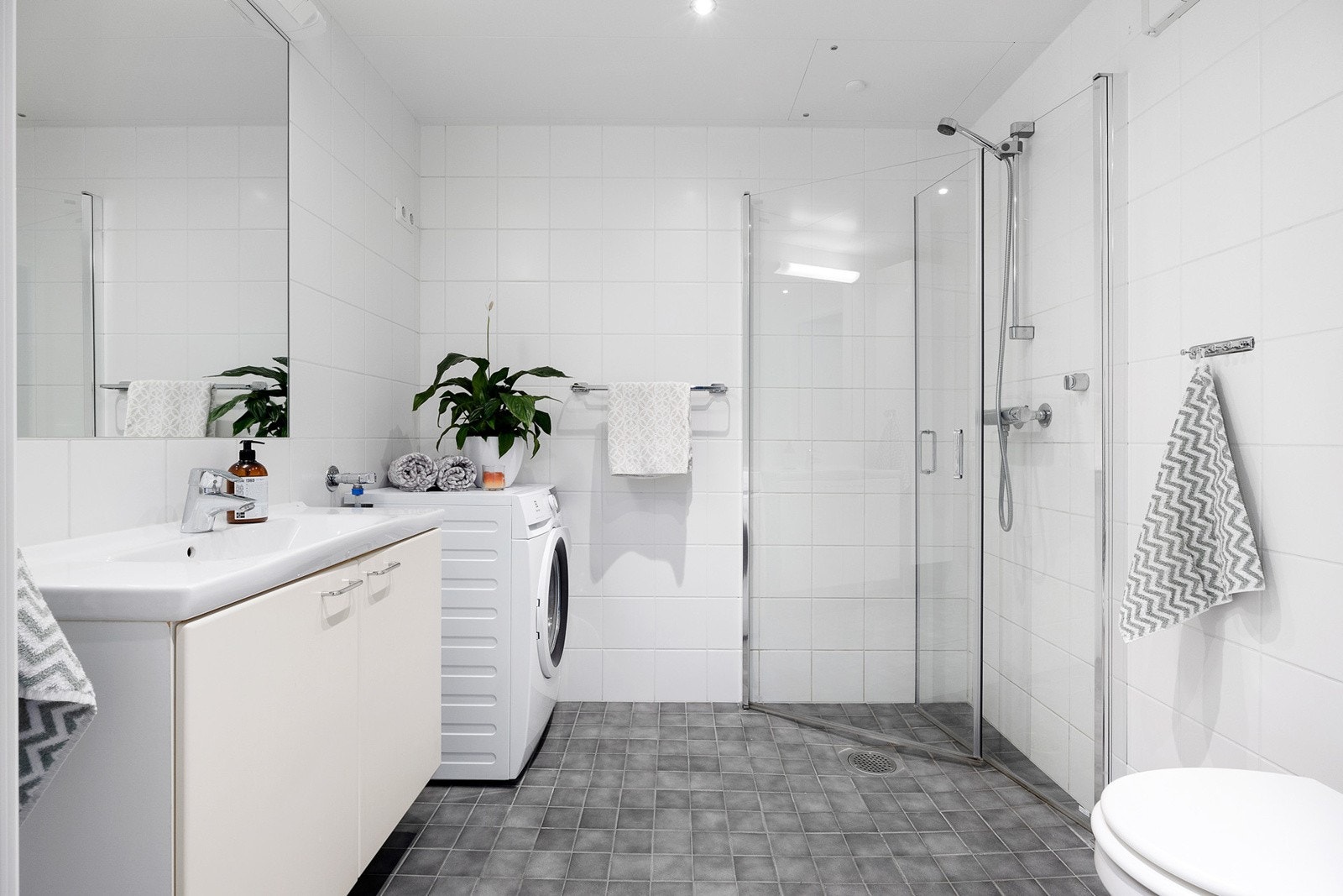 Stort flislagt bad med gulvvarme og downlights i tak. Galleribilde