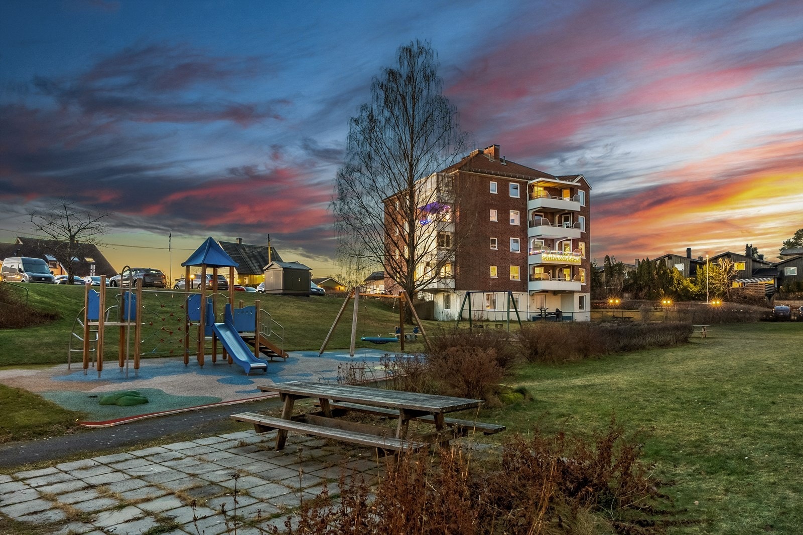 Pent opparbeidet fellesområde med sittebenker og lekeplass Galleribilde