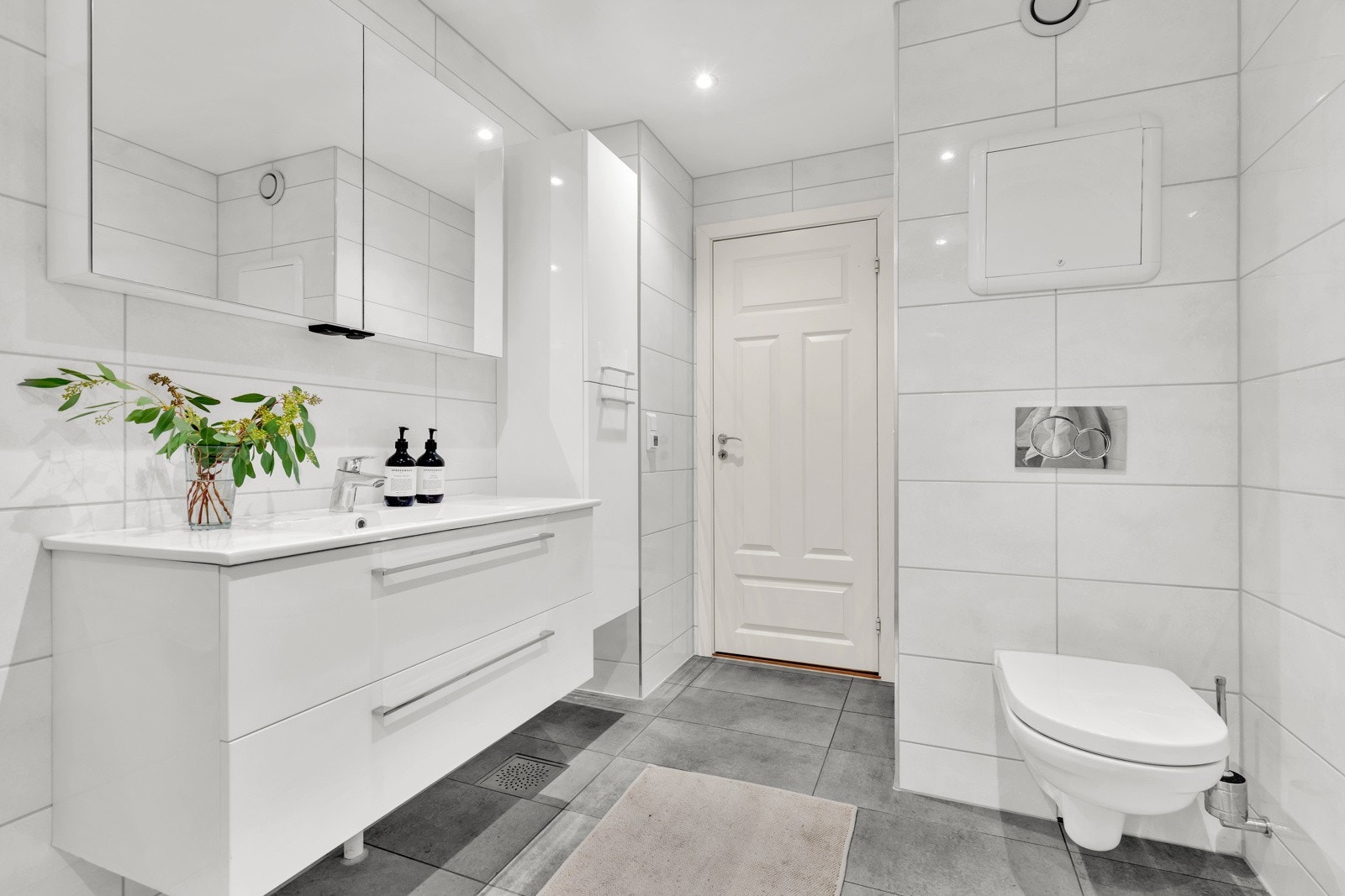 Badet består av vegghengt toalett, dusjhjørne og servant. Downlightsbelysning i himling og god skapplass. Galleribilde