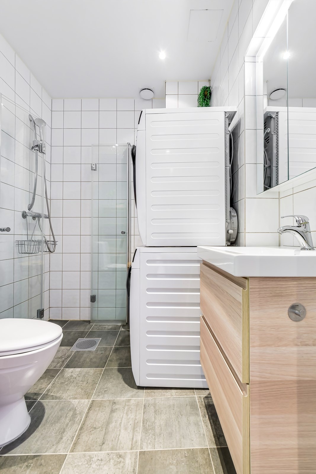 Tidløst og pent flislagt baderom med elektrisk varme i gulv og opplegg for vaskemaskin. Galleribilde