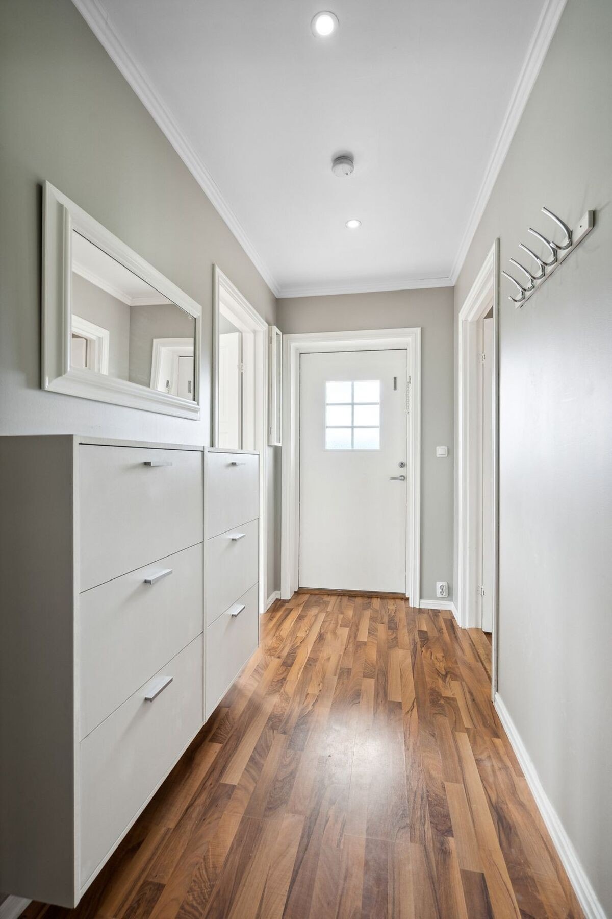 Gang med lyse og pene veggflater og med spotlights i himling. Galleribilde