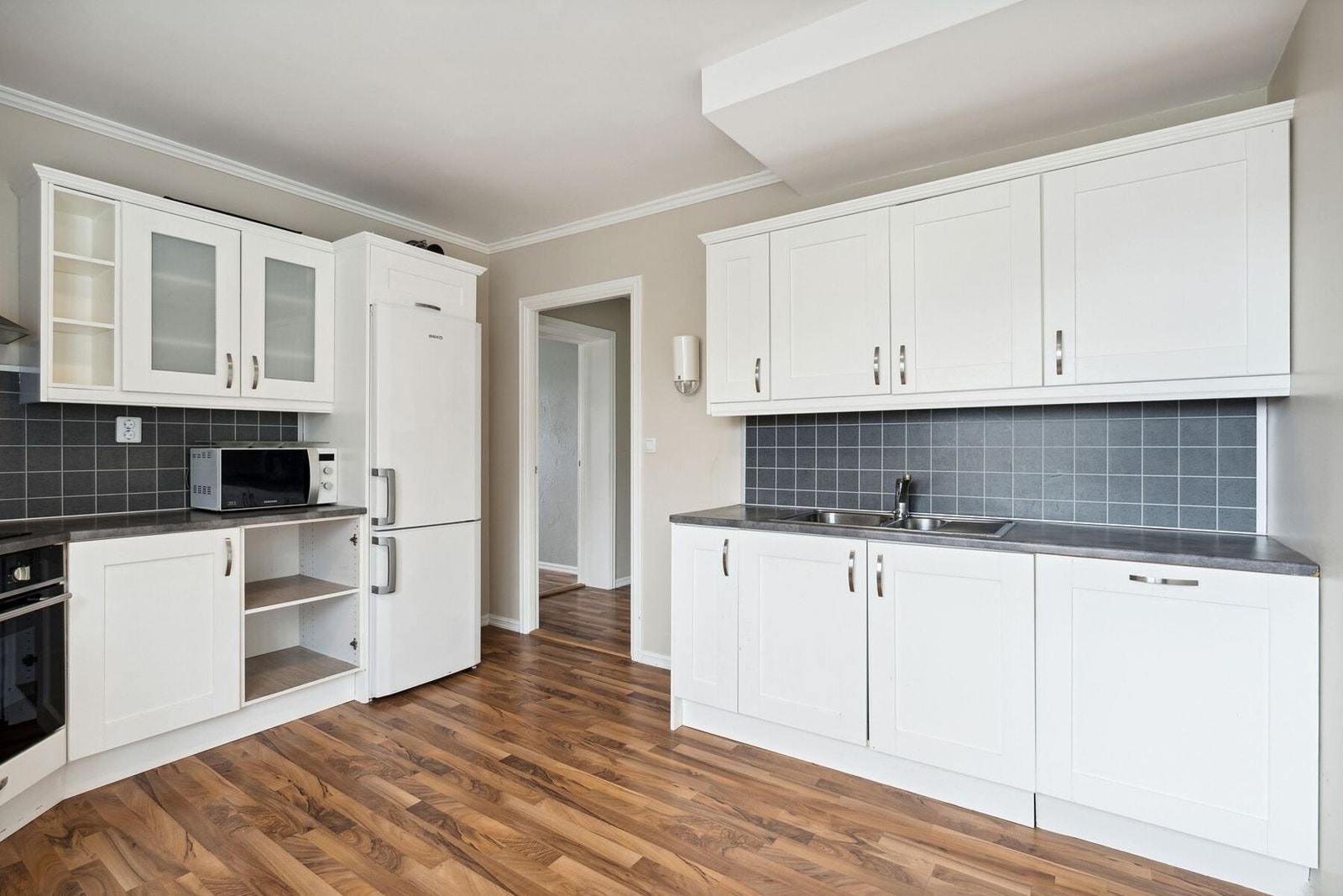 Integrerte hvitevarer som oppvaskmaskin, kjøl/frys, platetopp og stekeovn. Galleribilde